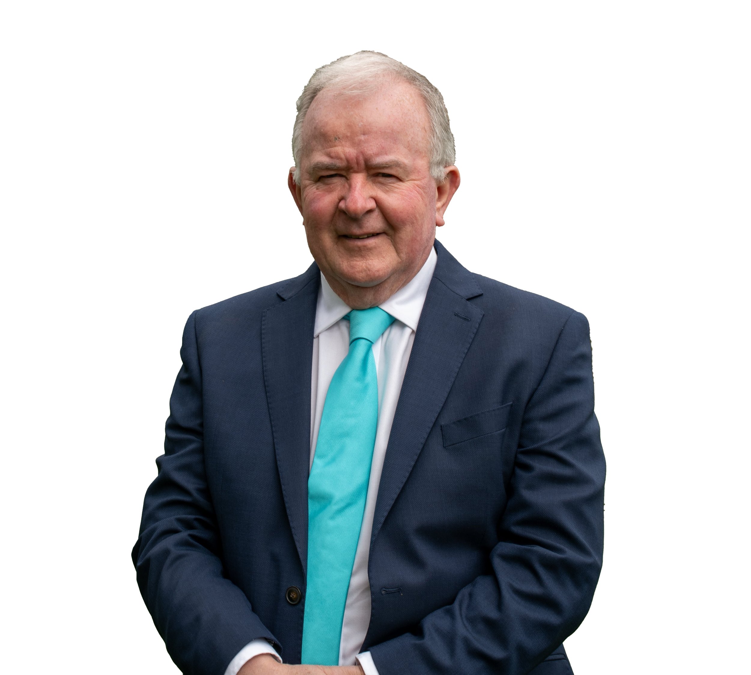 An elderly man with gray hair wearing a navy blue suit, white shirt, and a turquoise tie, standing against a white background.