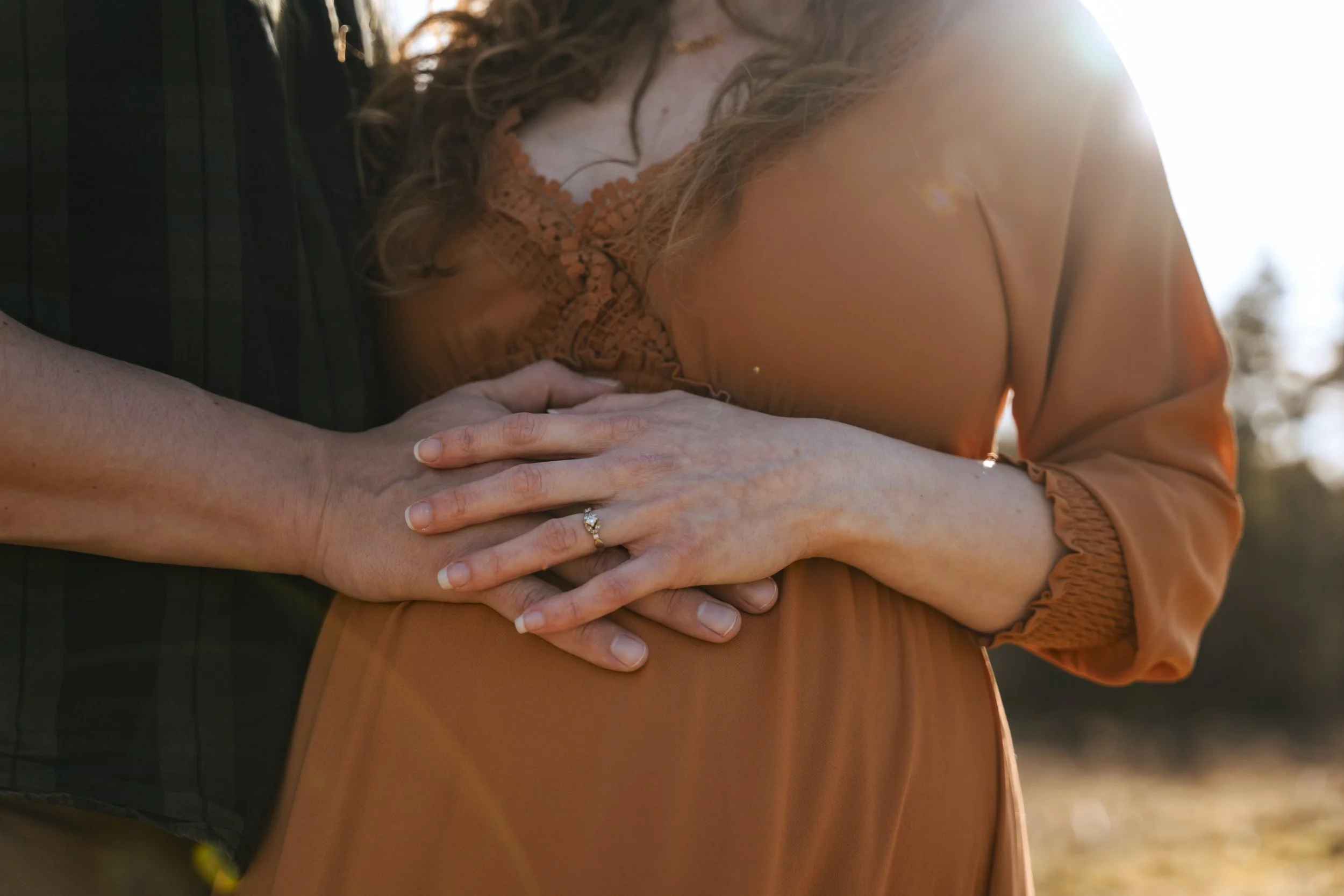 Zwei Hände liegen auf Schwangerschaftsbauch