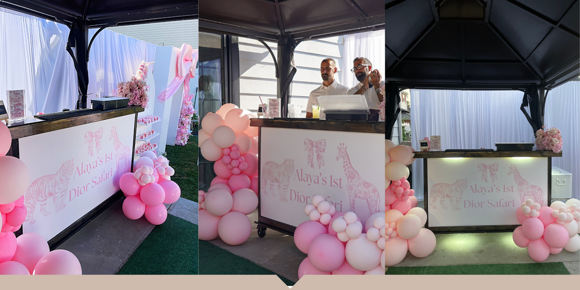 Decorated pink and white balloon arrangements surround a wooden snack or beverage stand with a sign that reads "Alaya's 1st Dior Safari" featuring illustrations of a tiger, zebra, and giraffe. In the middle, two men stand behind the stand, one holdin