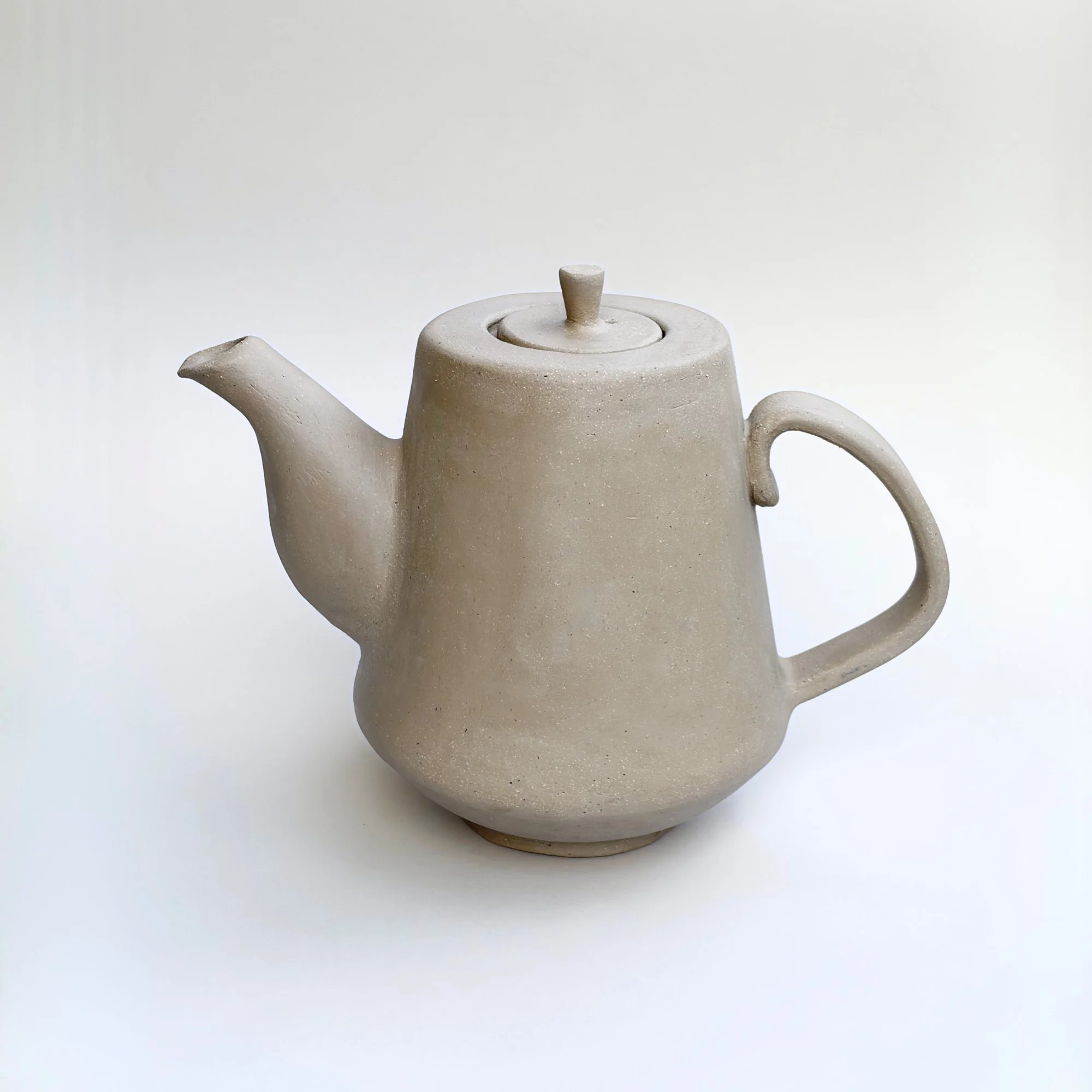 Beige handmade pottery teapot with round body, spout and lid, shown as inspiration for pottery template and ceramic template designs, ideal for slab pottery and beginner ceramics.