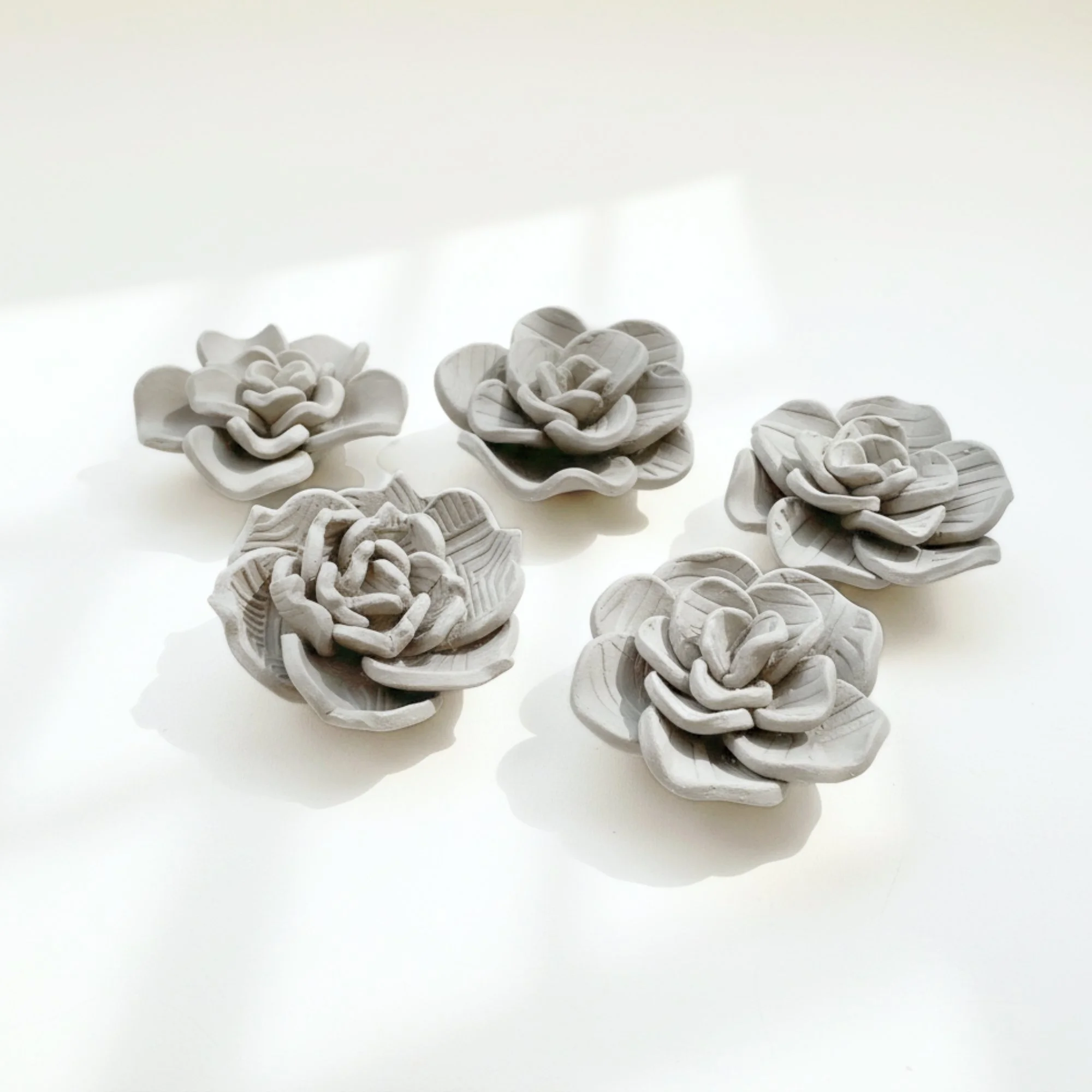 Set of five handmade clay flowers created from a succulent flower template, ideal for air dry clay projects, handmade pottery and ceramic template lovers.