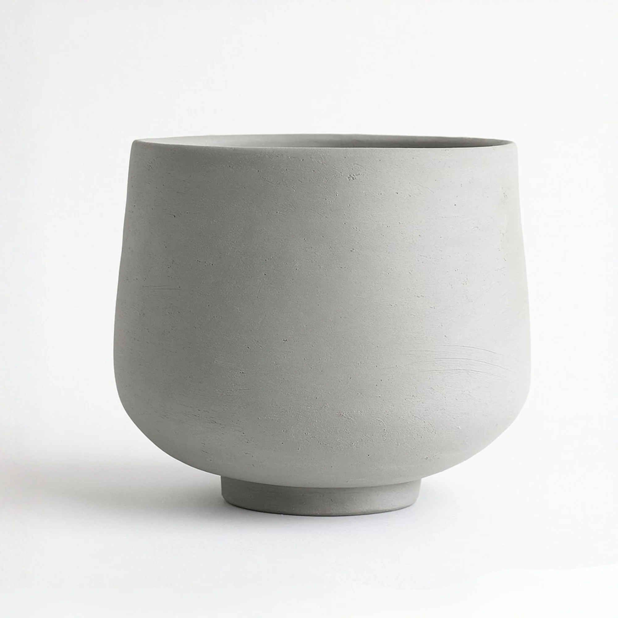 Unfired tumbler with a footring, made with a DIY pottery template, smooth lines for a modern handmade look, ideal for beginner pottery.