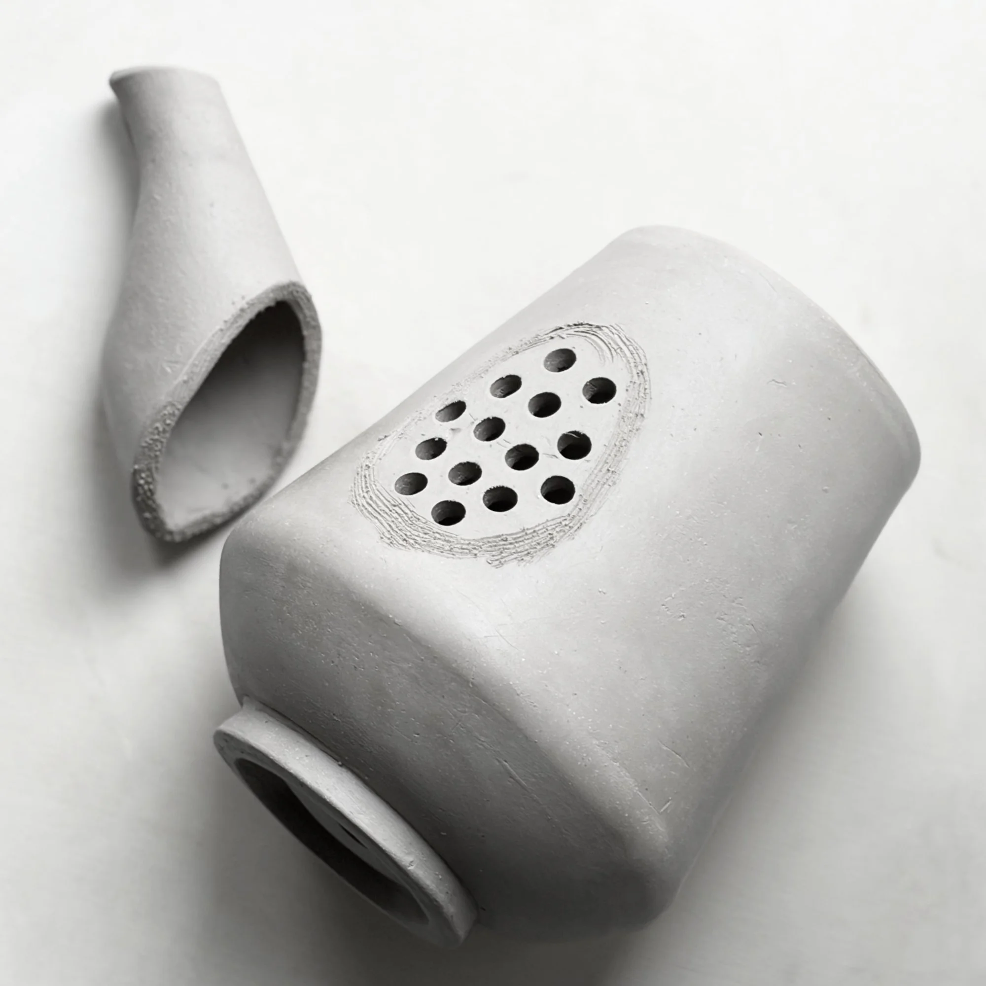 Adding a slab-build spout to a slab-built teapot using a pottery template as a pottery tool.