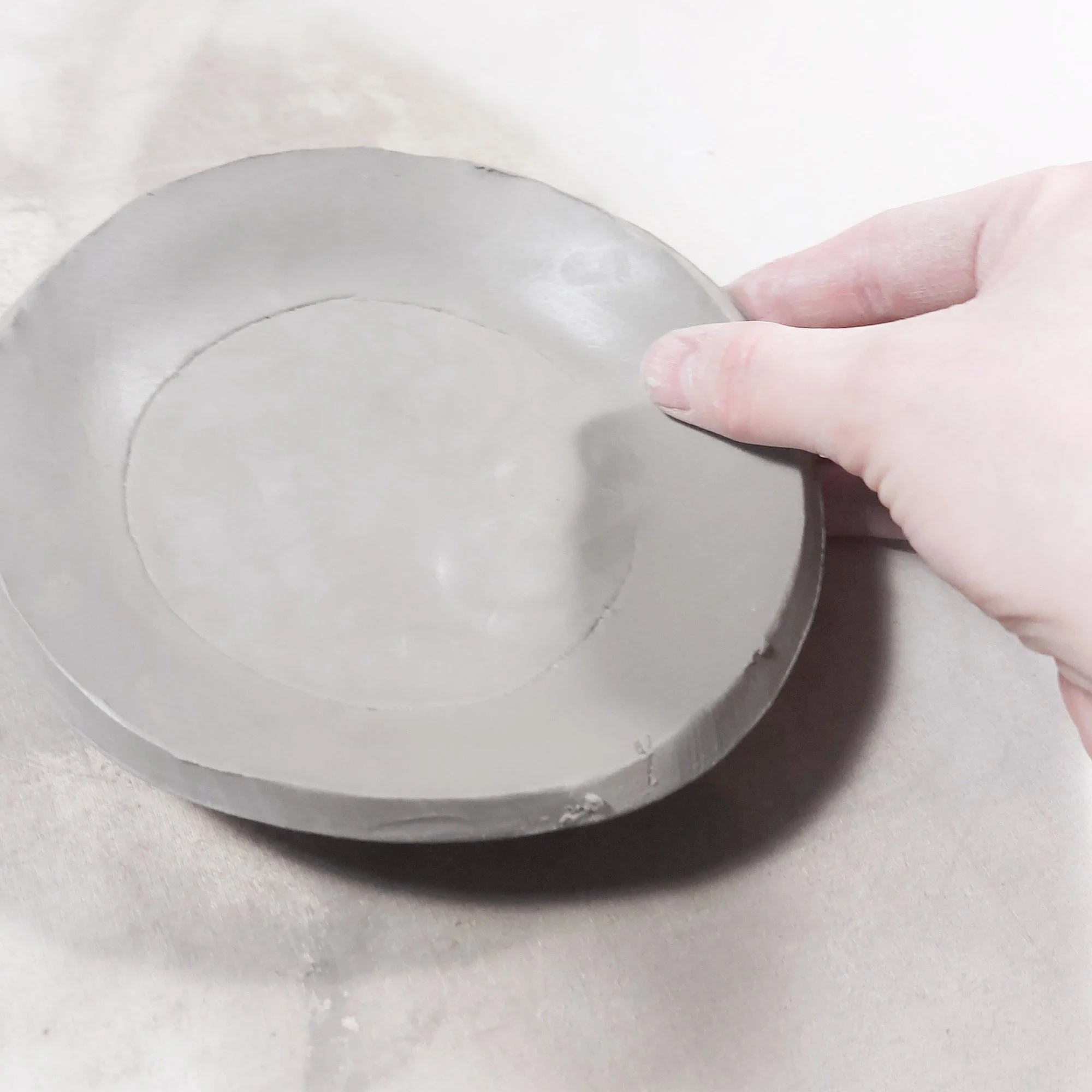 Shaping the slab base of a teapot created using a teapot pottery template