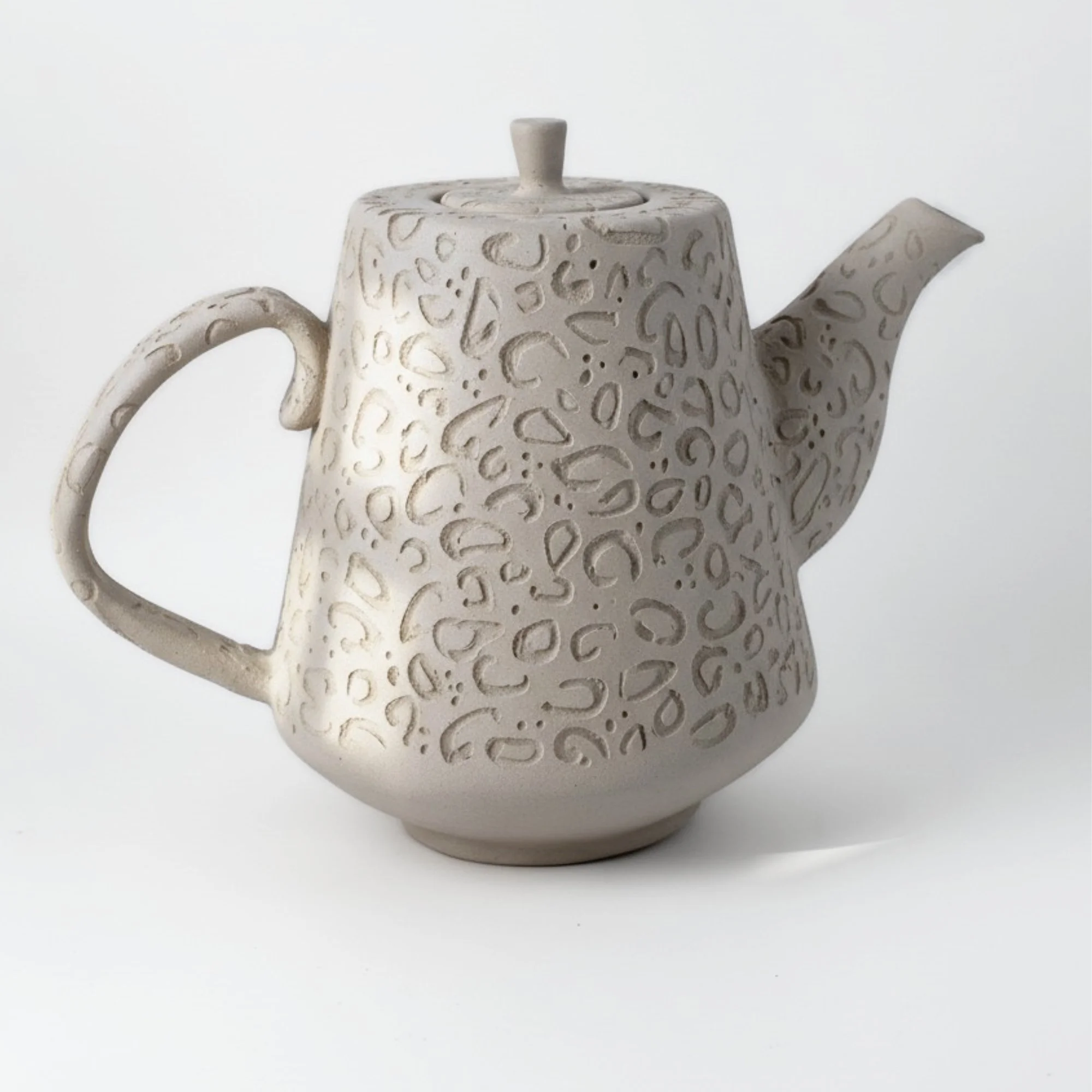 a slab-built teapot with a carved lepard pattern, result of using a teapot pottery template by Skillforge Creations.