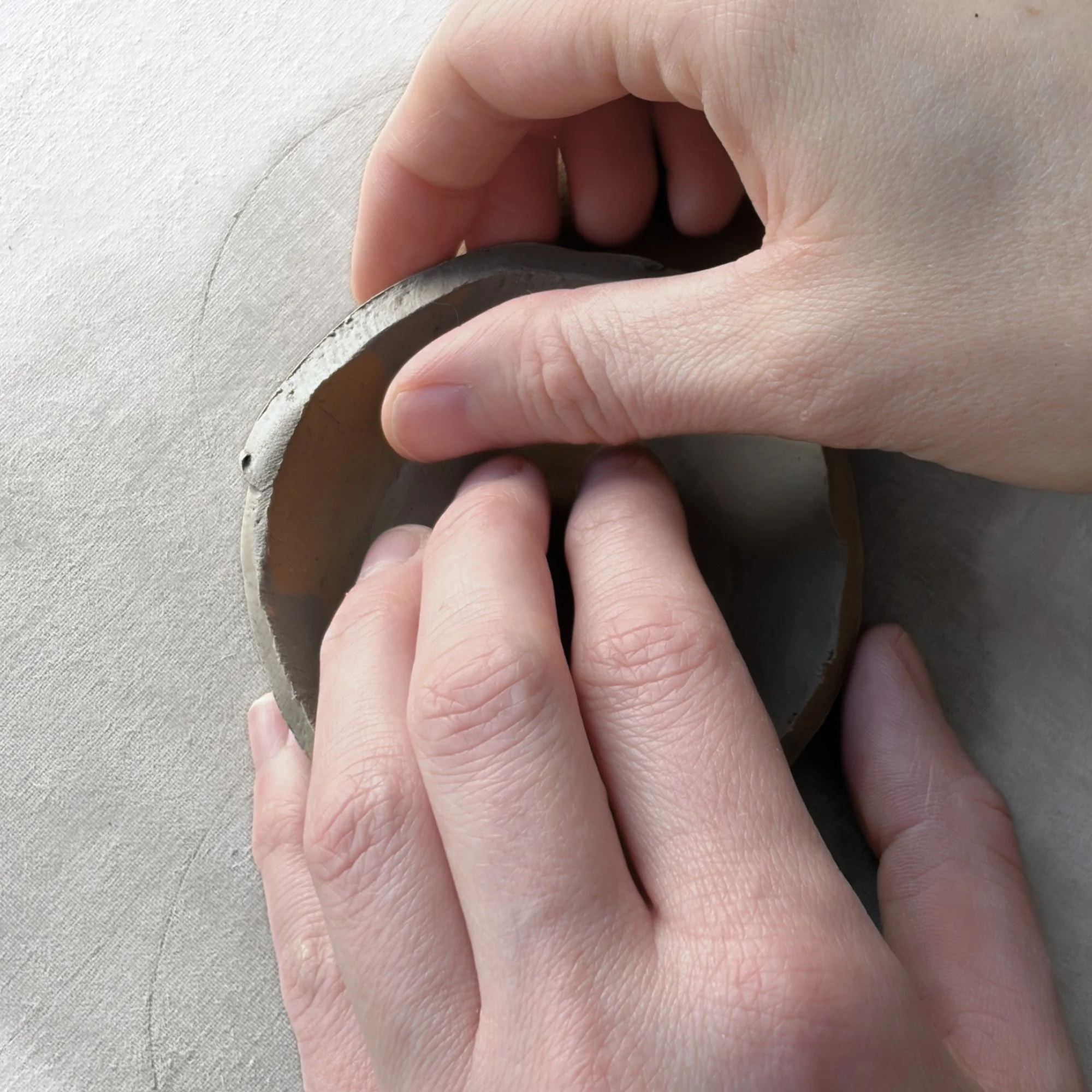 shaping the base of an espresso mug with a handbuilding technique using a free mug pottery template.