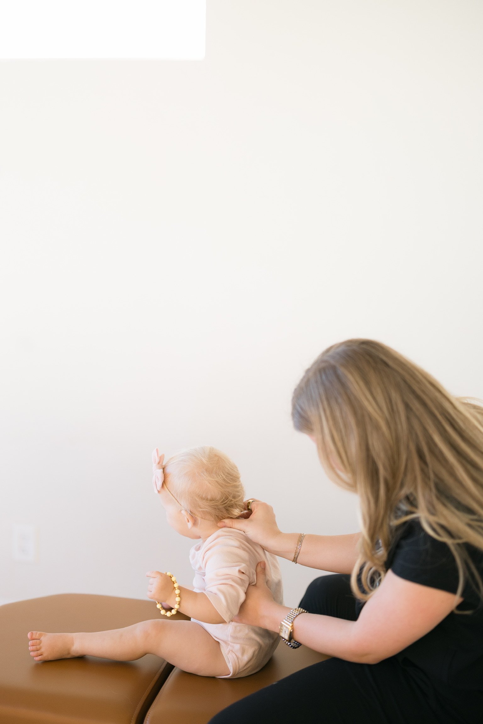 Dr. Kamryn Good gently adjusting a newborn in Tulsa, Oklahoma, providing expert pediatric chiropractic care to support nervous system development and healthy growth.