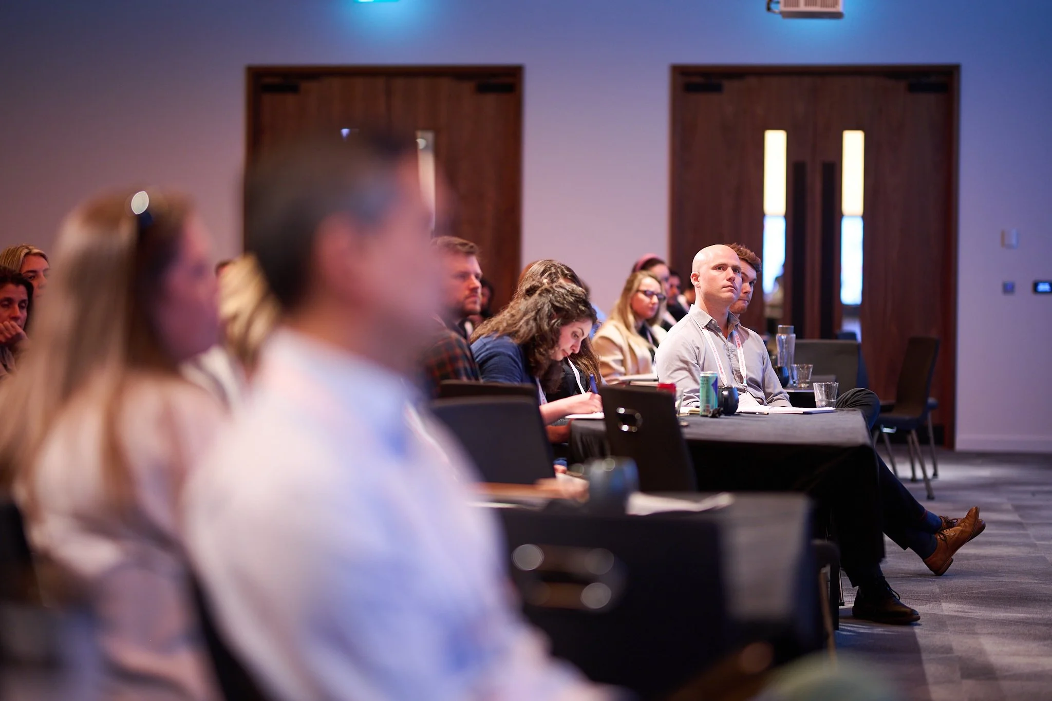 Audience members attentively listening at a conference
