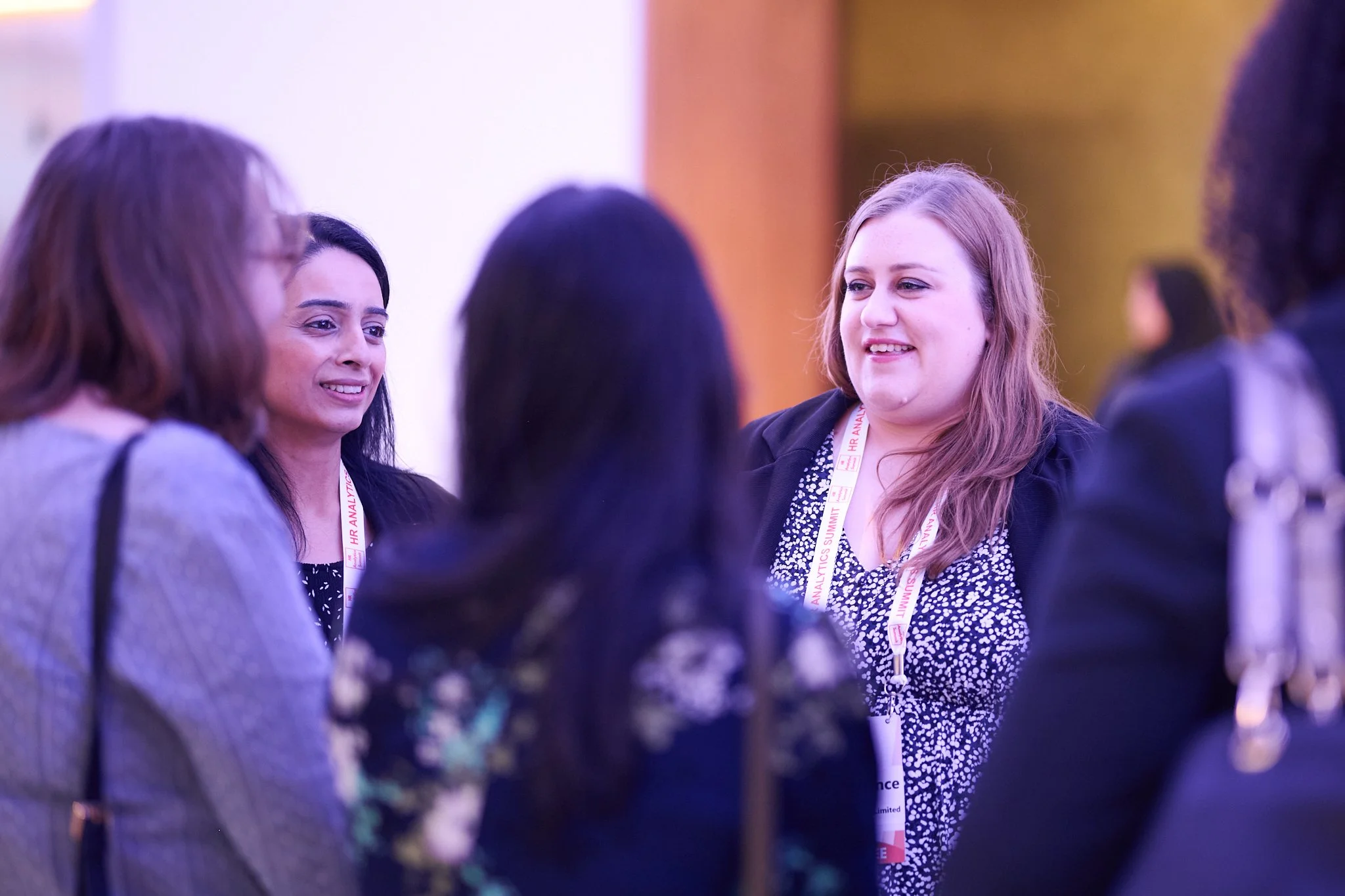 Group of women networking at a conference, wearing name badges