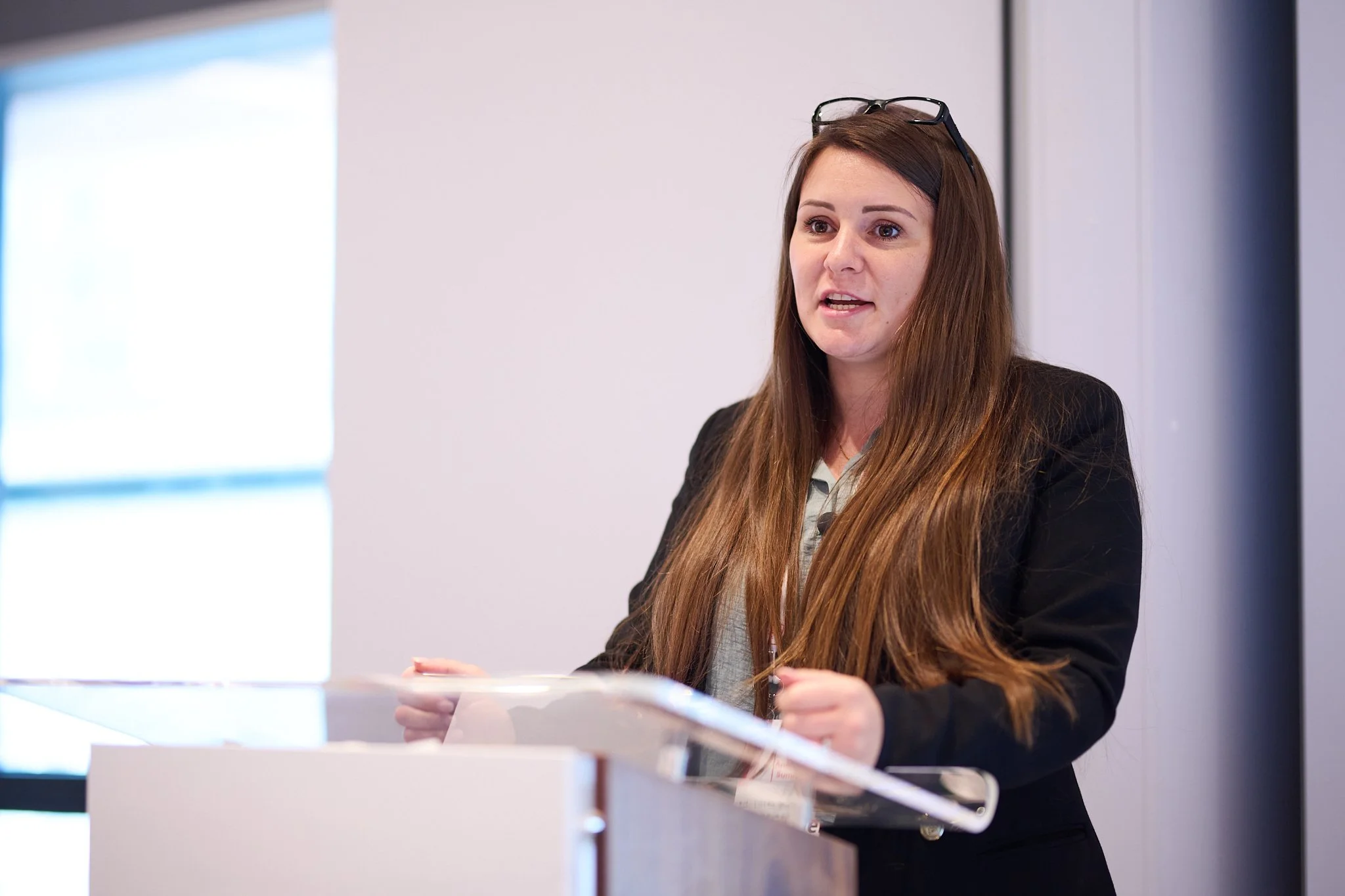 Woman giving a presentation at a podium.