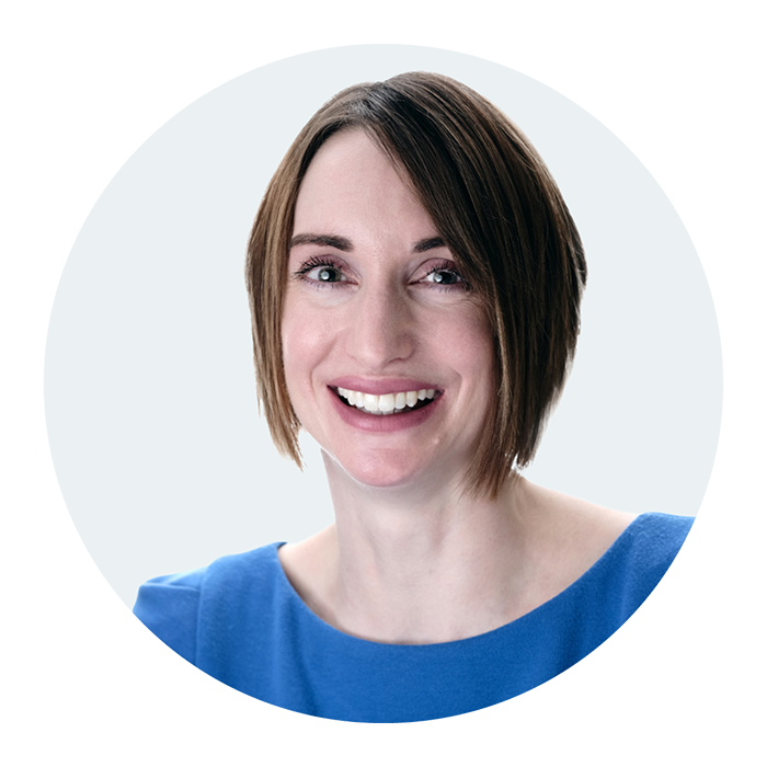 Headshot of Emily McArthur, counsellor at Clear Insight Counselling, against a pale blue background. She has short brown hair and is wearing a bright blue top, looking at the camera smiling.