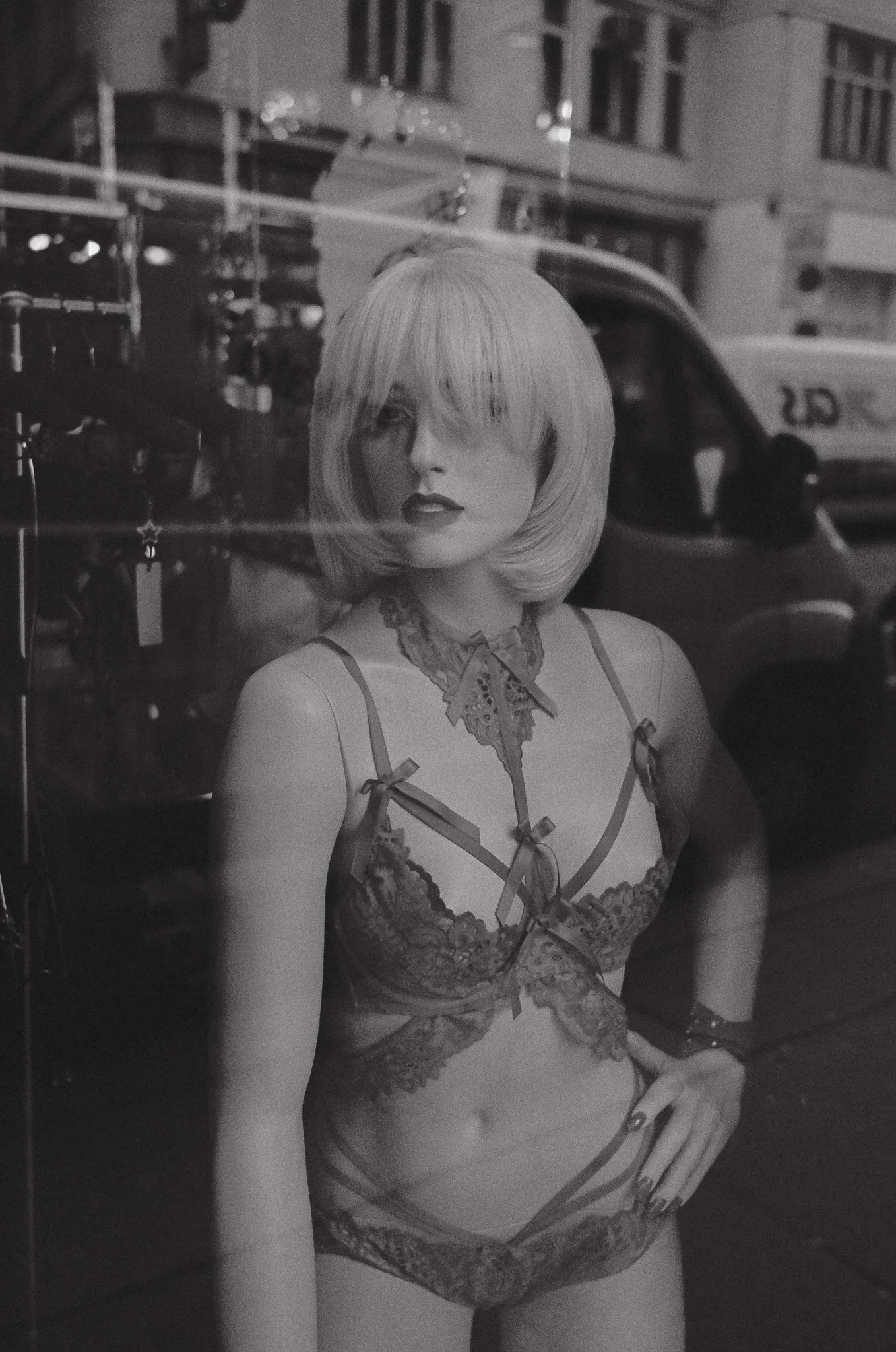 Figura di una donna in vetrina, vestita con lingerie di pizzo.