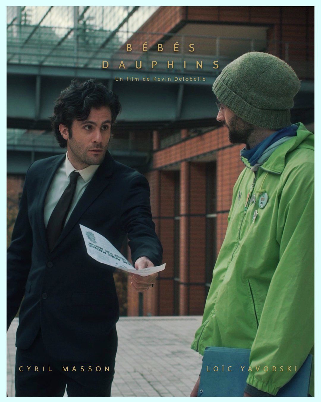 Deux hommes discutent à l'extérieur d'un bâtiment moderne en briques avec un toit en verre, l'un en costume noir et l'autre en veste verte avec des badges.