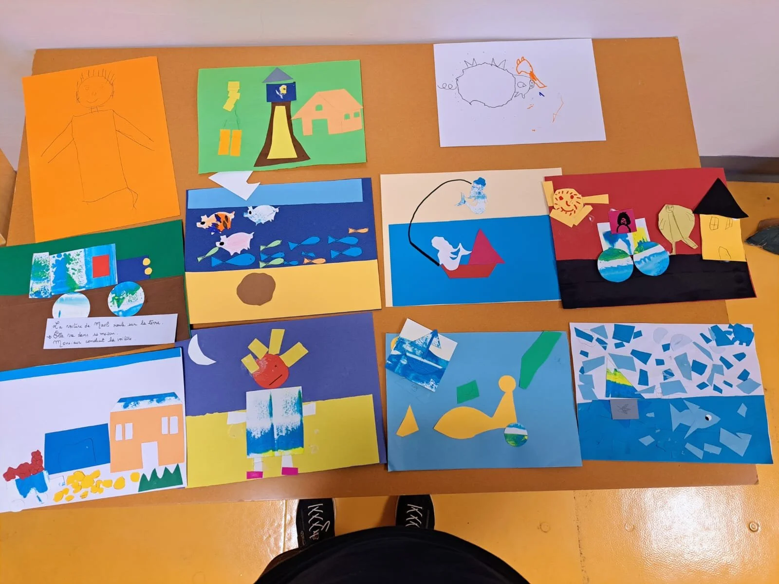 Collection de plusieurs dessins et collages colorés réalisés avec des papiers découpés, représentant des scènes diverses comme des paysages, des animaux, des maisons, et des personnages.