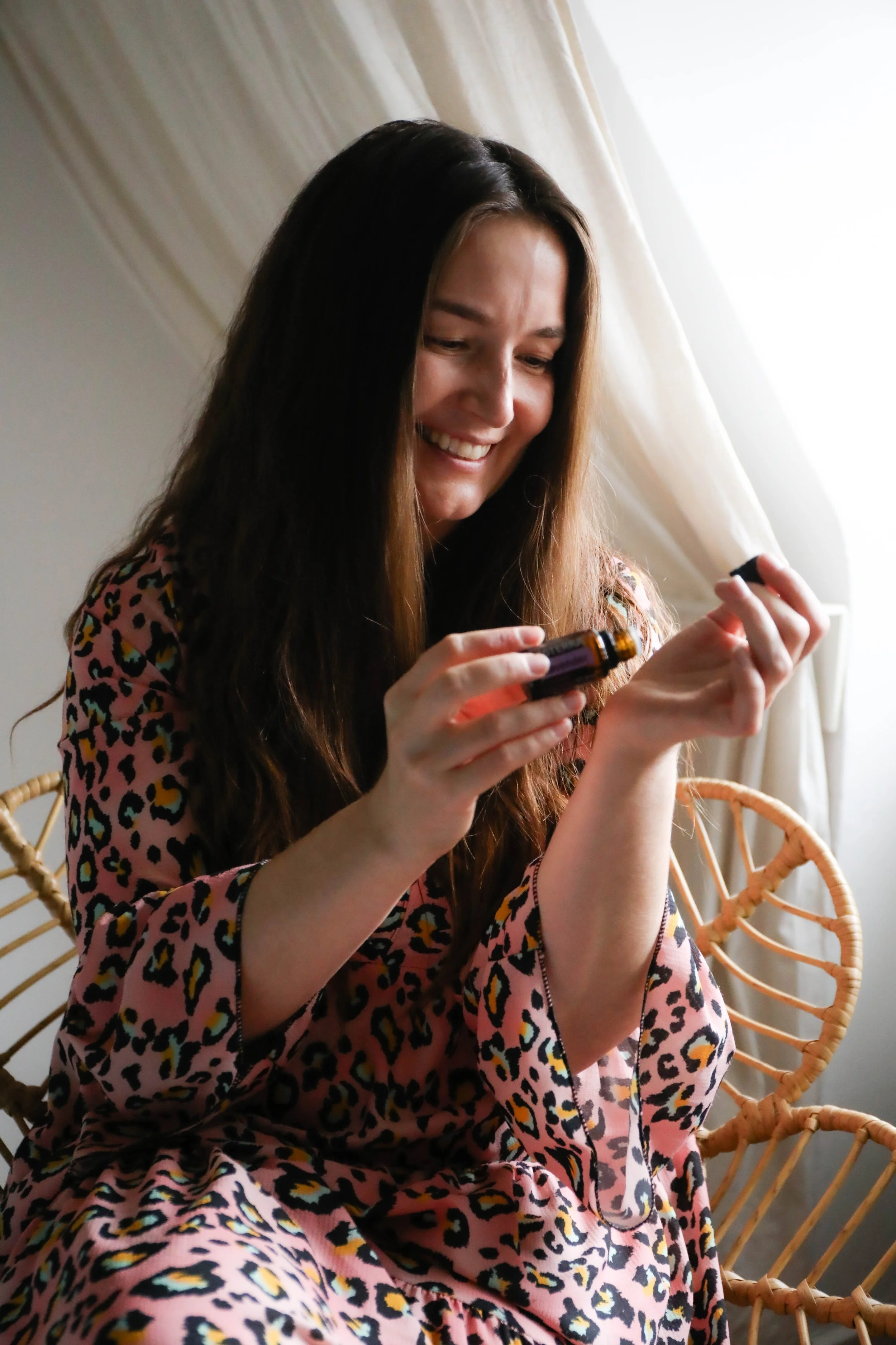 dōTERRA Beraterin Christin Reese lächelt im Korbsessel mit einem ätherischen Öl – Individuelle Beratung für ganzheitliche Gesundheit.