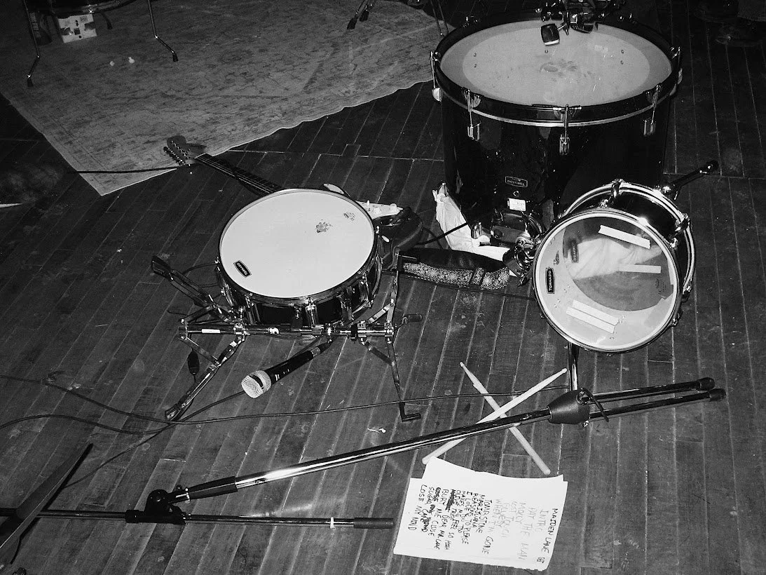 Maiden Lane setlist next to a broken acoustic drum kit. 