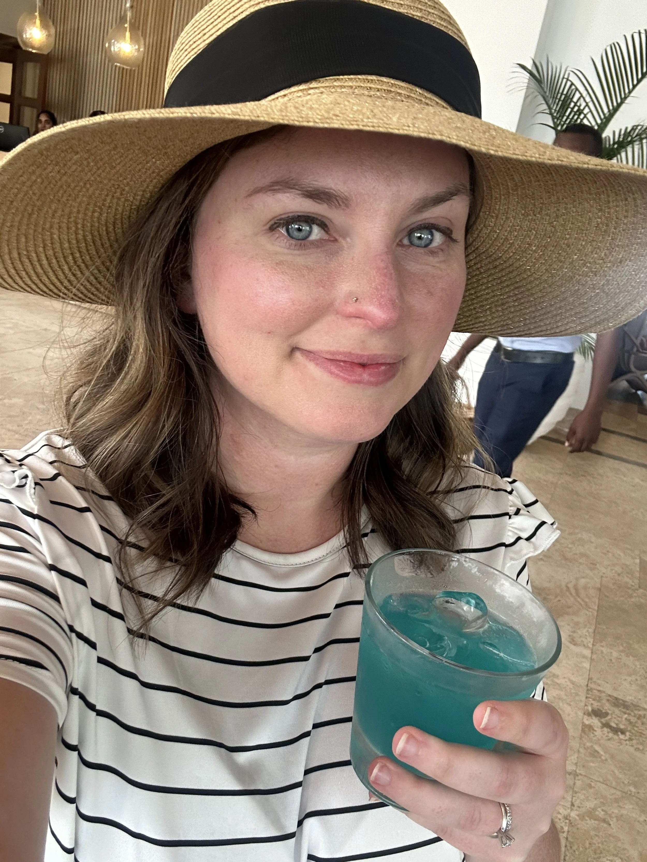 Travel agent at Caribbean resort with drink in hand