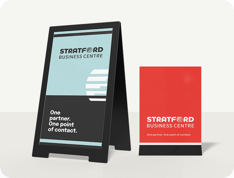 A digital menu board and a menu card stand with mockup designs for a sandwich shop.