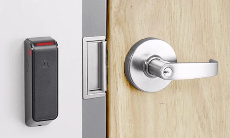 Electric strike and card reader securing a controlled access door in a commercial facility.