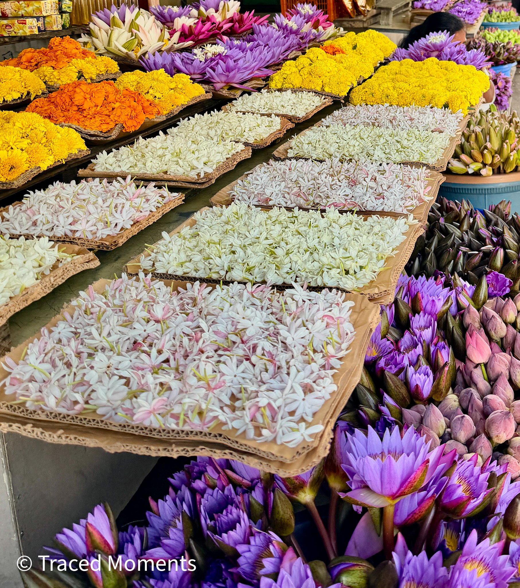 The flower market in front of a temple.
