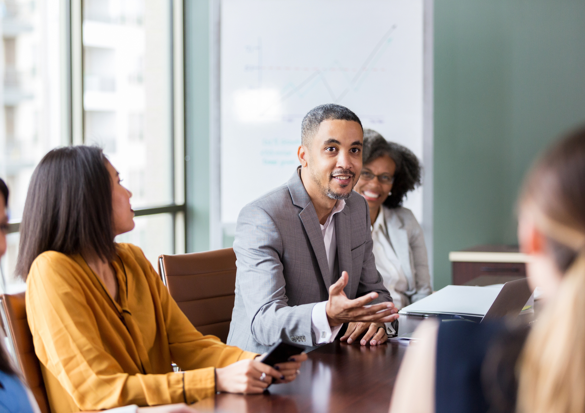 Homme en costume pointant une interface holographique avec des icônes de technologie