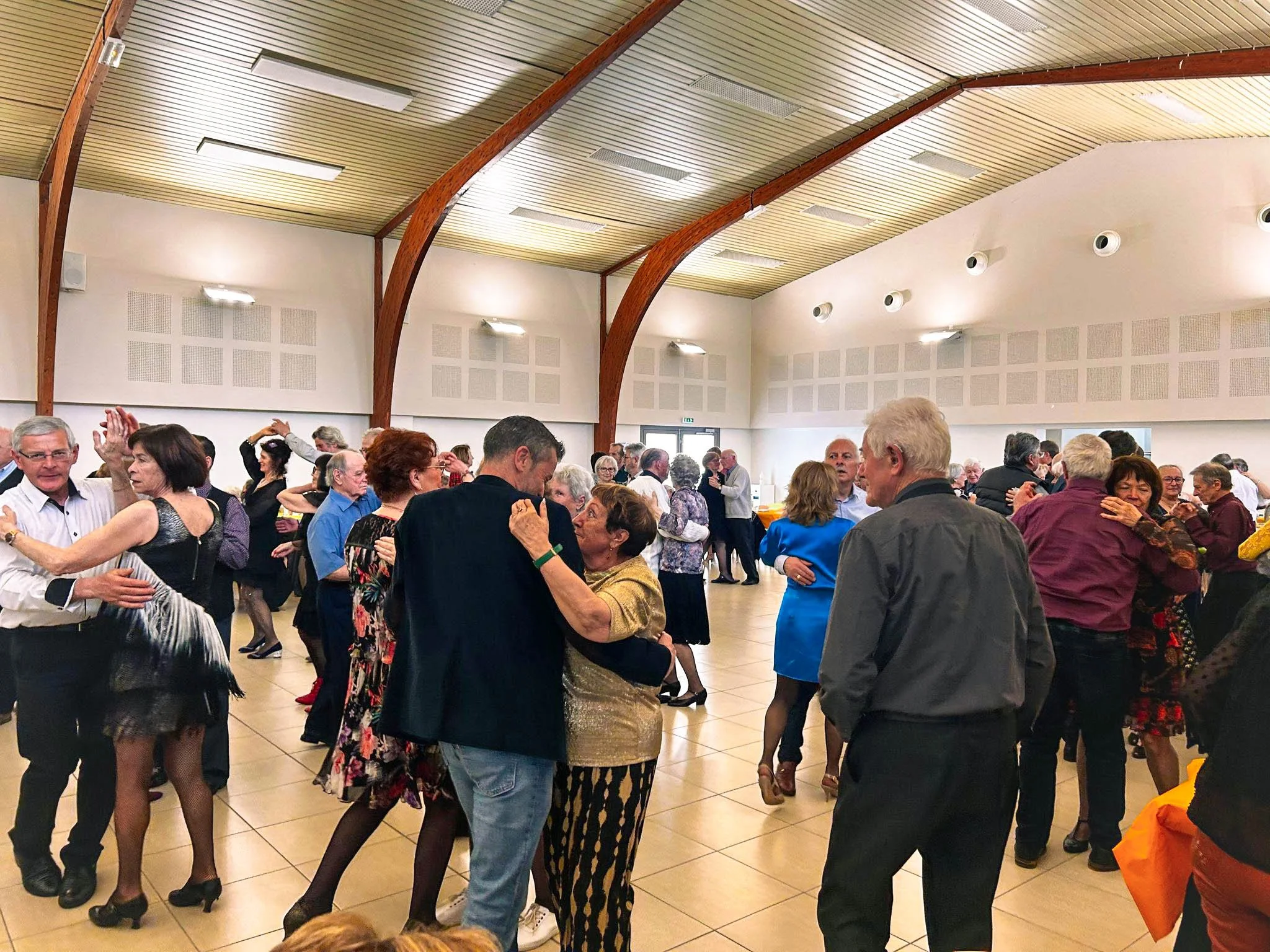 Groupe de personnes dansant dans une salle de bal.
