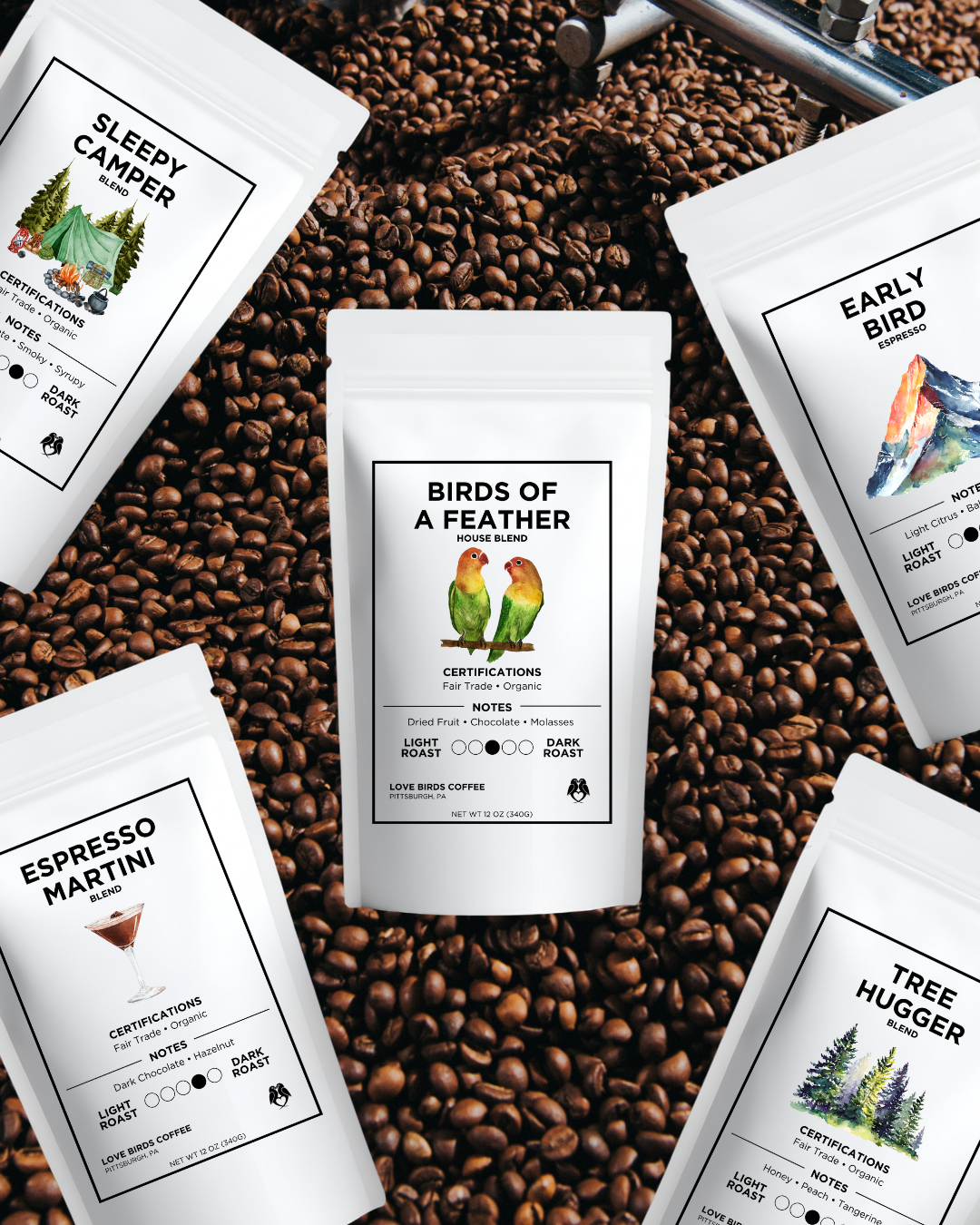 Various bags of coffee beans on a bed of roasted coffee beans, with labels indicating different blends and flavor notes.