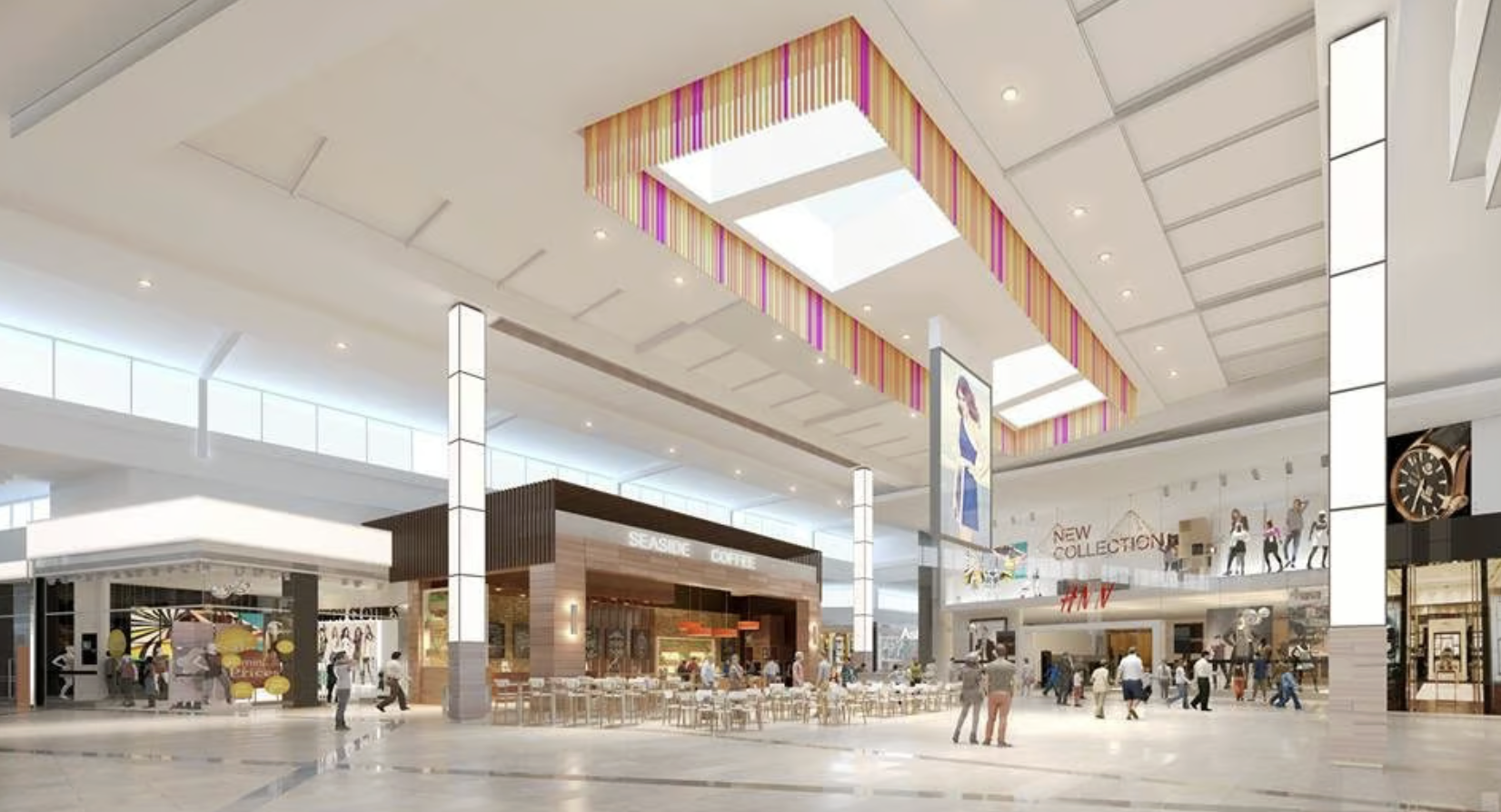 Interior of a modern shopping mall with various stores, seating area, large digital advertisements, and bright lighting.