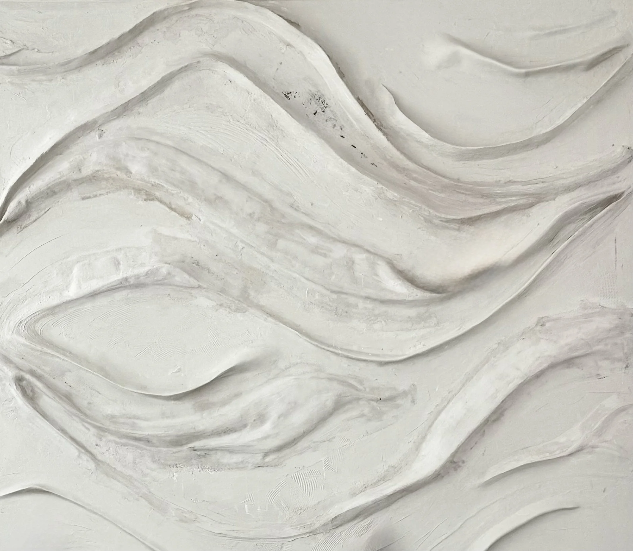 Abstract white textured wall with flowing, wave-like patterns.