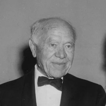 Black-and-white photo of an elderly Maxwell Aitken in a tuxedo with a bow tie, smiling slightly.