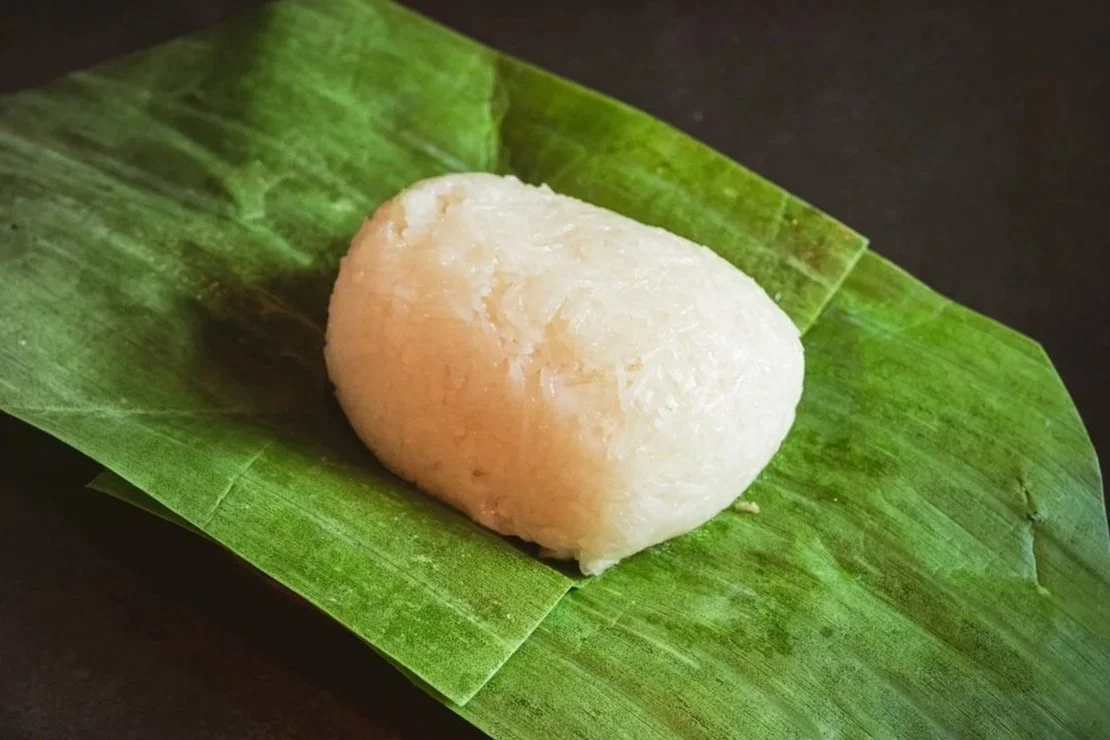 A mound of steamed sticky rice served on a fresh banana leaf.