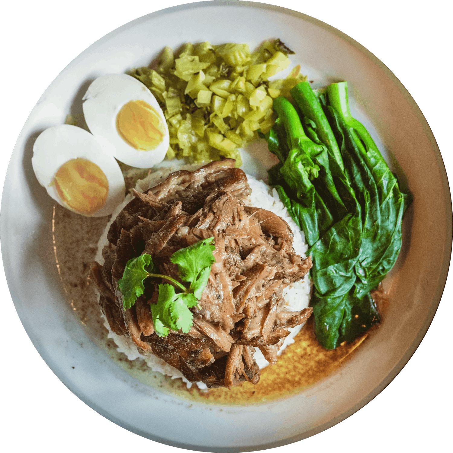 A plate of Khao Kha Moo with hard-boiled egg, pickled mustard green, asian broccoli, jasmine rice topped with soy braised pork and garnished with cilantro.