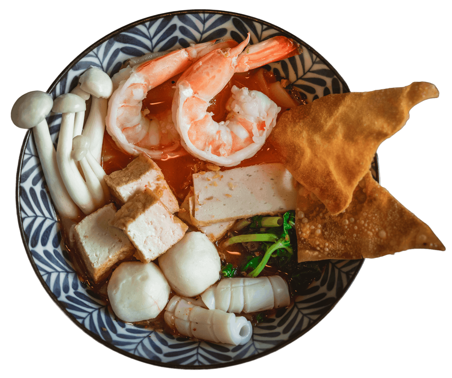 Krabi Seafood Noodle in a patterned bowl with whole shrimp, fish balls, bean curd, fermented tofu, mushrooms, and a crispy wonton skin in a deep red tomato pork broth.