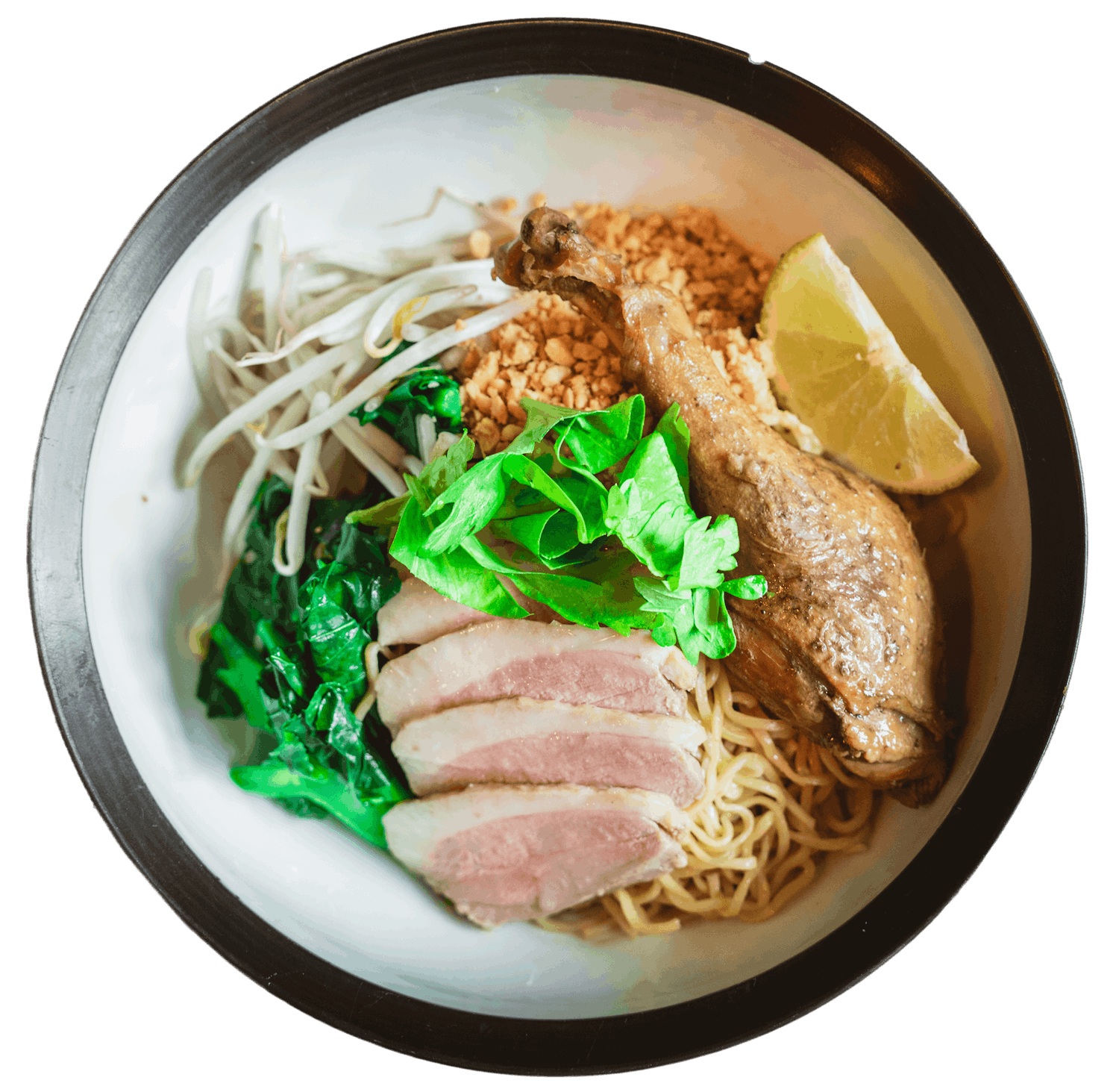 Dry Nakhon Chai Si Noodle in a black bowl with egg noodles, sliced duck, a crispy duck leg, water spinach, bean sprouts, and a wedge of lemon.