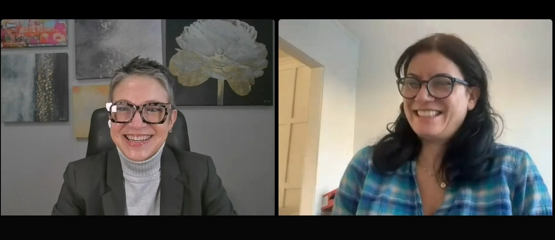 Two women smiling during a video call, one with short gray hair and glasses wearing a blazer and turtleneck, the other with long dark hair and glasses wearing a blue plaid shirt.