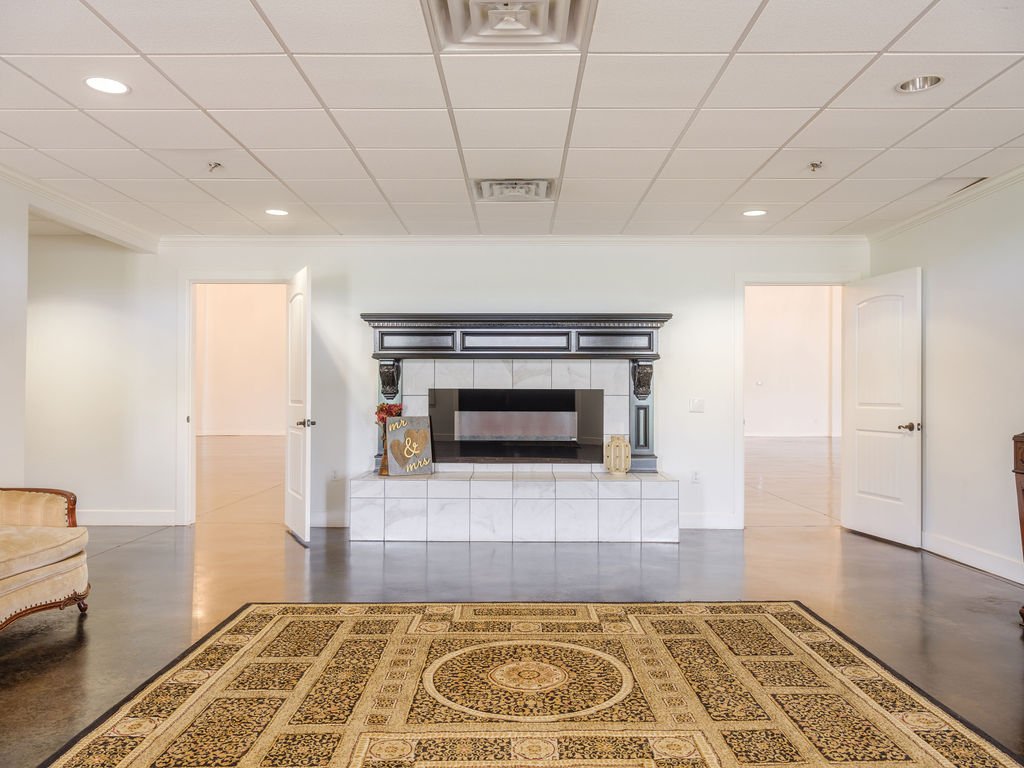 Living room with white walls, a fireplace with black trim, and an ornate area rug.