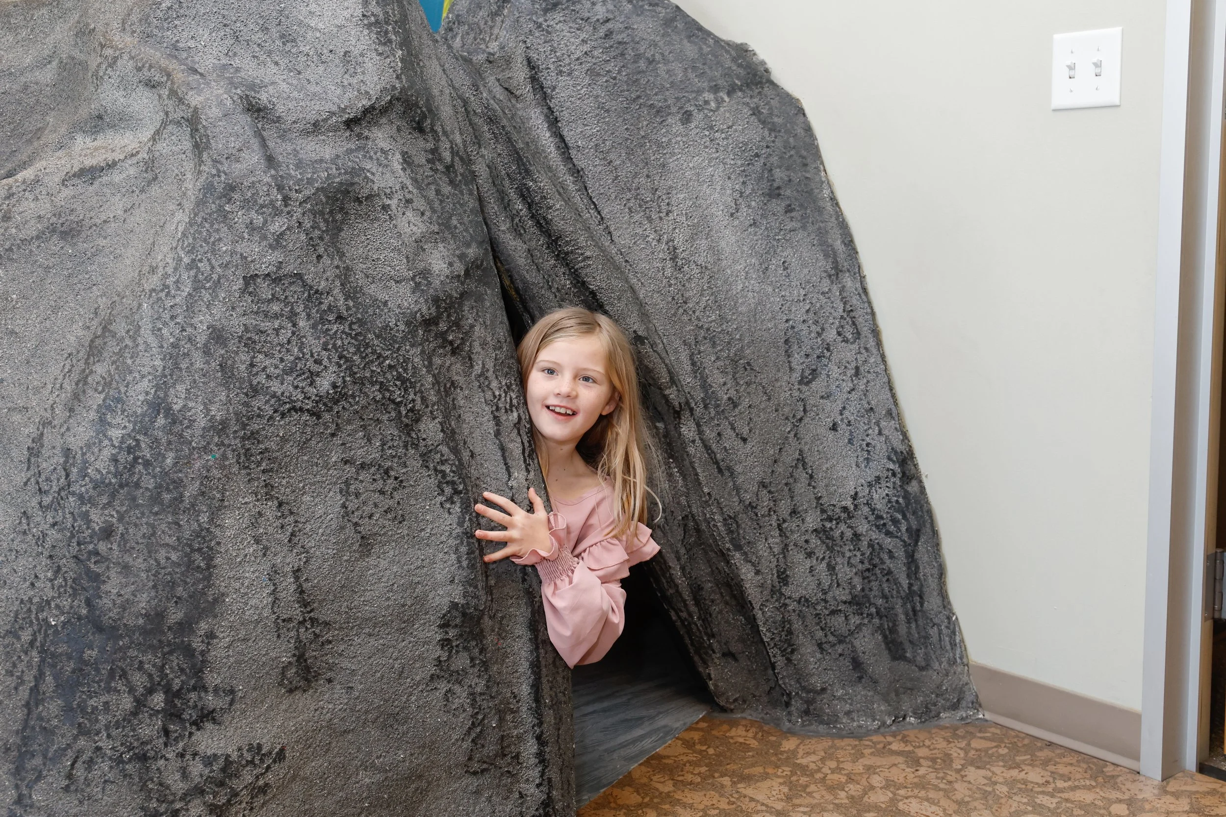 A kid playing in a cave at Lotus Tree Therapy Hub.
