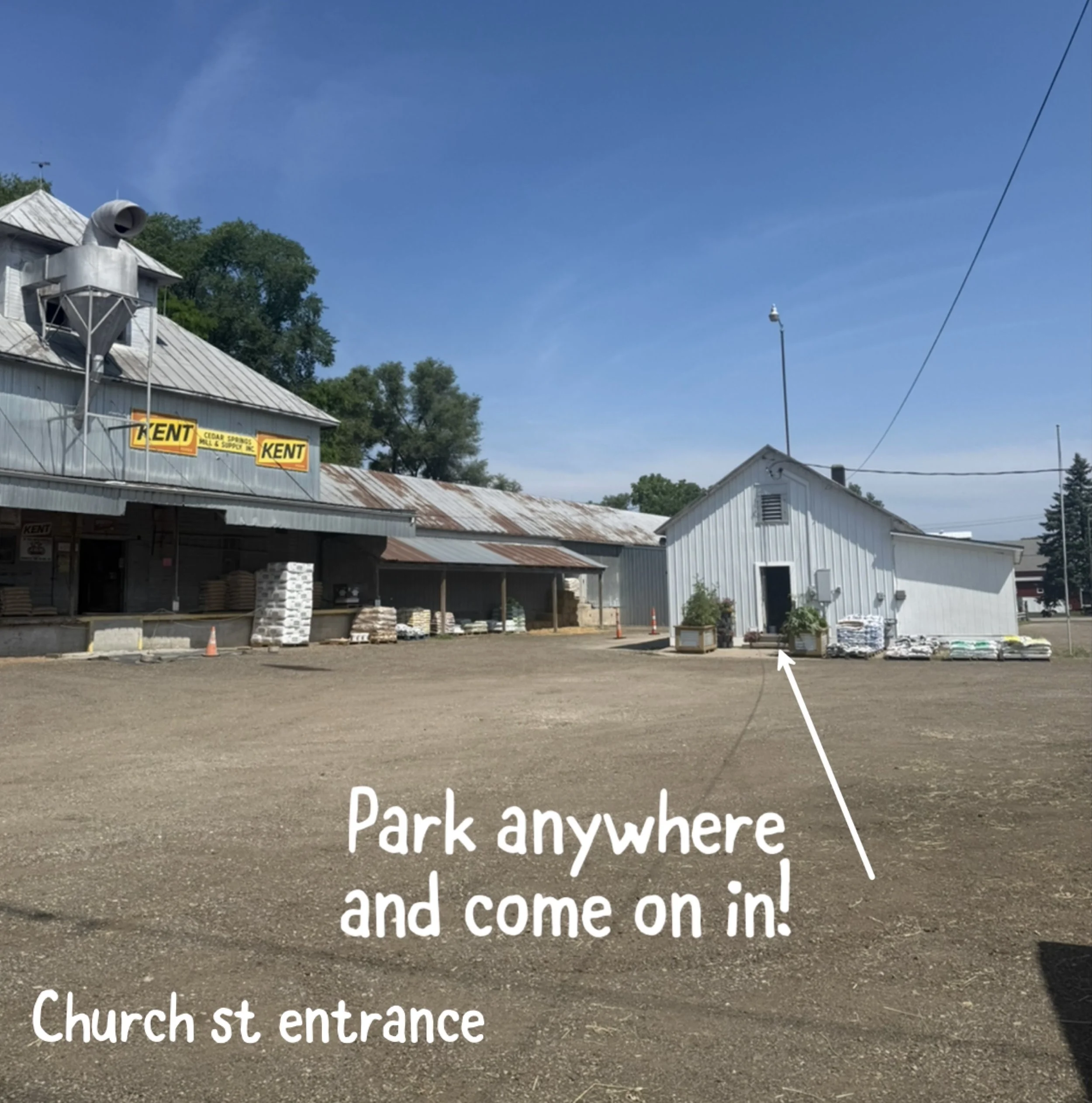 Sign in a parking lot indicating the entrance on church st, with text reading 'Park anywhere and come on in! Church st. entrance'