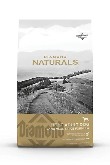 A bag of Diamond Naturals Light Adult Dog food with lamb meal and rice formula, featuring a rural landscape with rolling hills and a dirt path.