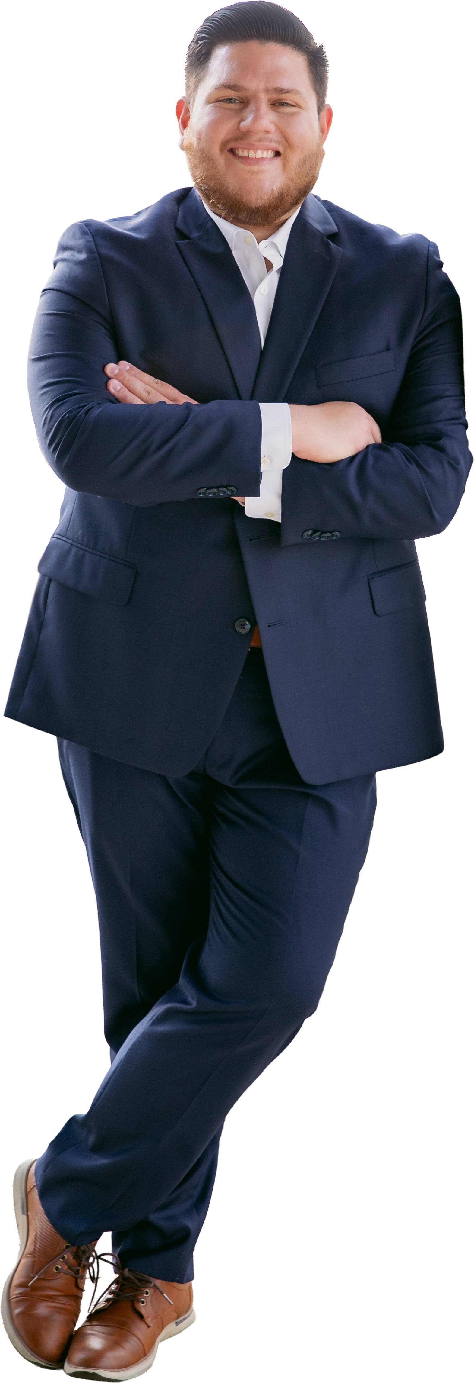Smiling man in navy suit with crossed arms, white shirt, brown shoes, standing confidently.