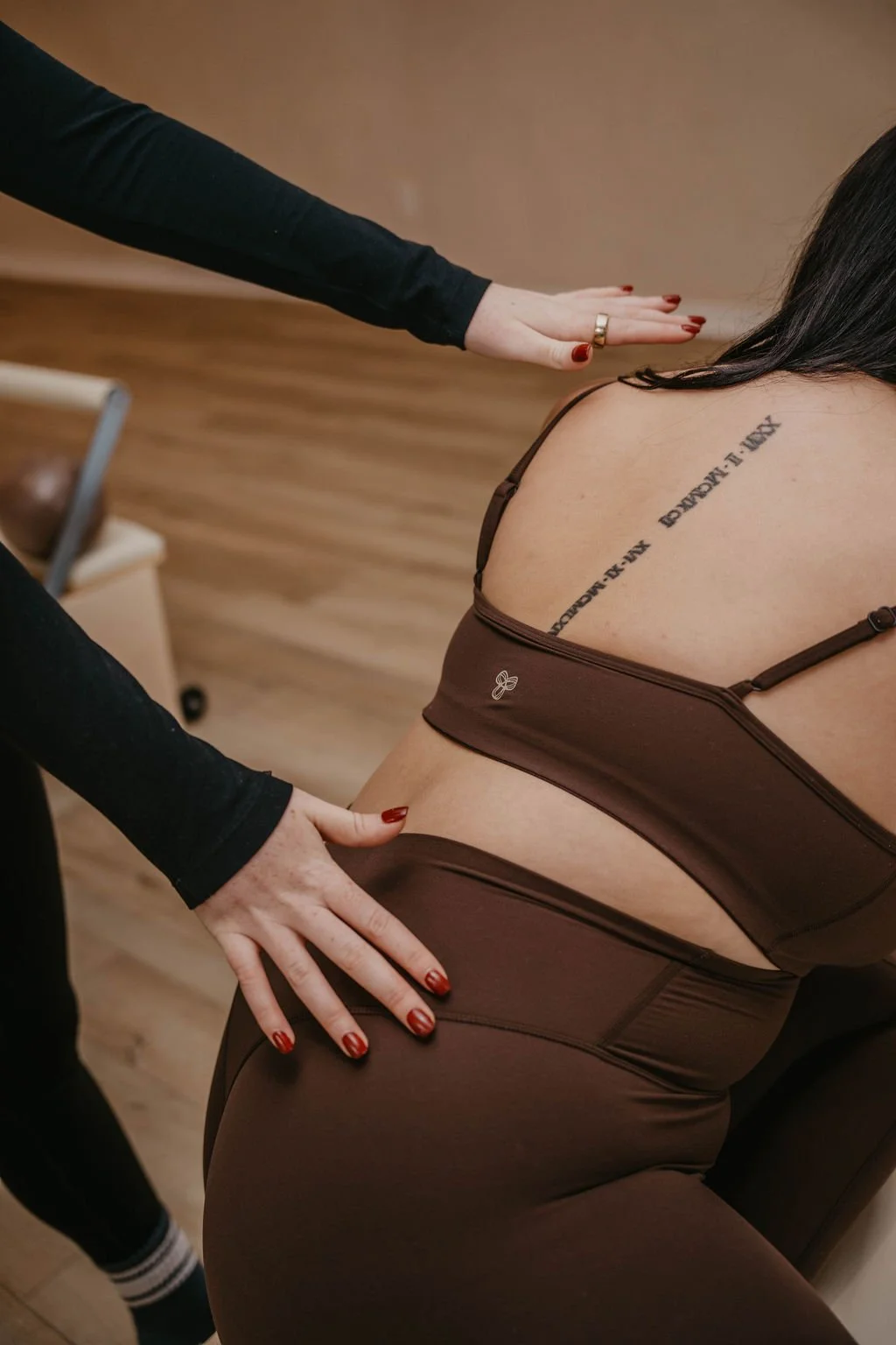 A person receiving a chiropractic adjustment or massage from a therapist, focusing on the lower back.