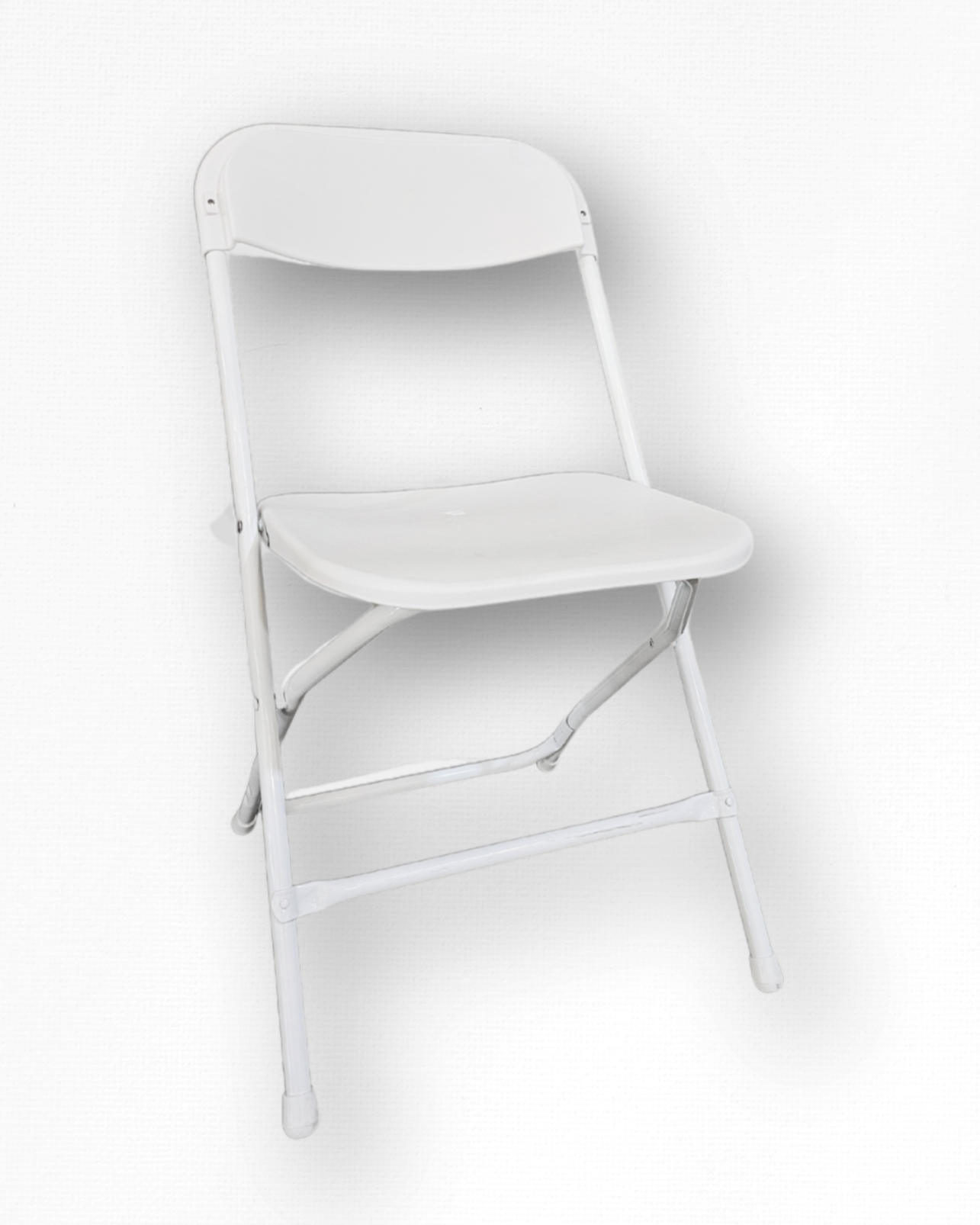 White folding chair against a textured white wall.