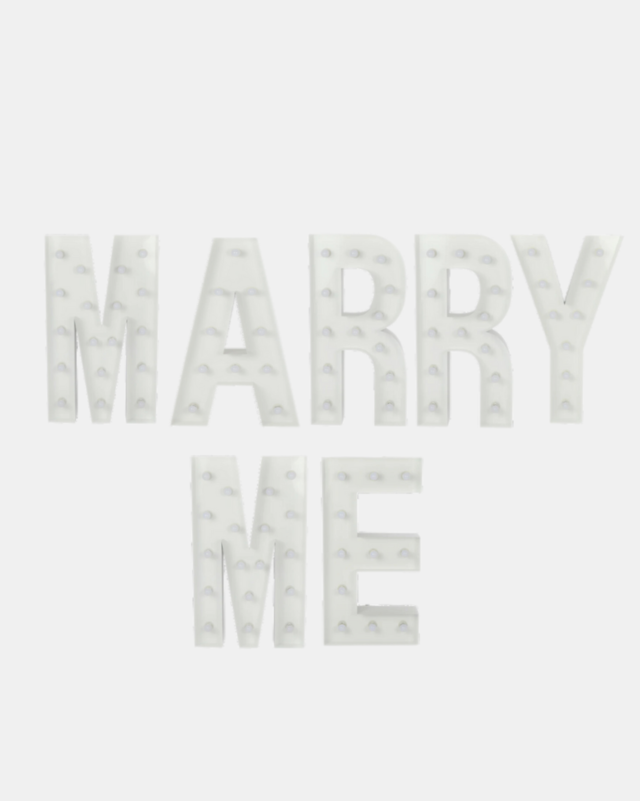 White illuminated marquee sign spelling out 'MARRY ME' on a light grey background.