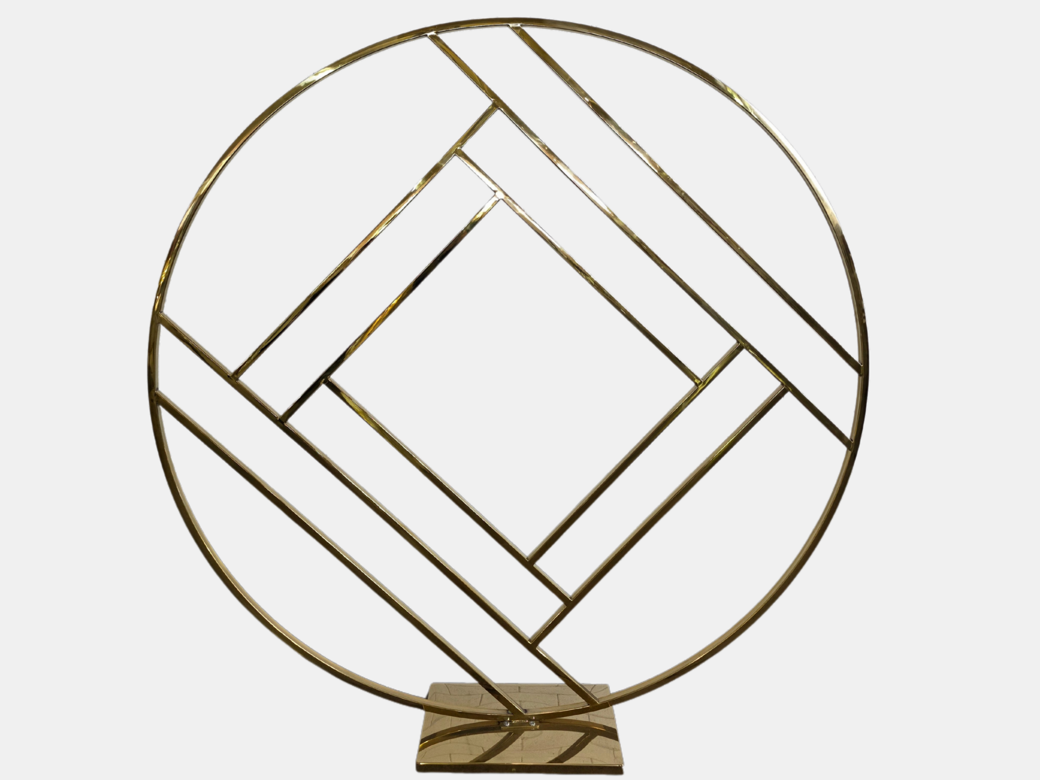 A modern gold-colored metal sculpture featuring intersecting lines and shapes within a circular frame, mounted on a rectangular base.