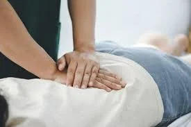 Person receiving a chiropractic adjustment on the low back.