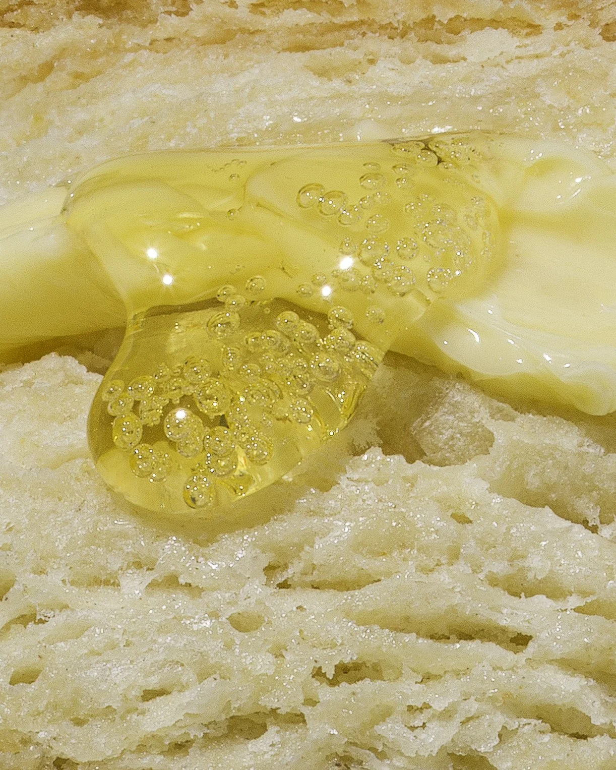 Close-up of a buttermilk biscuit with butter and honey.