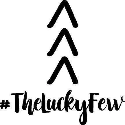 Three black upward arrows over a hashtag and the words '#TheLuckyFew' in black cursive font.