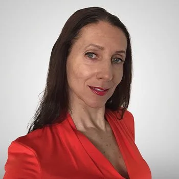 A woman with long dark hair wearing a red dress, smiling slightly against a plain background.