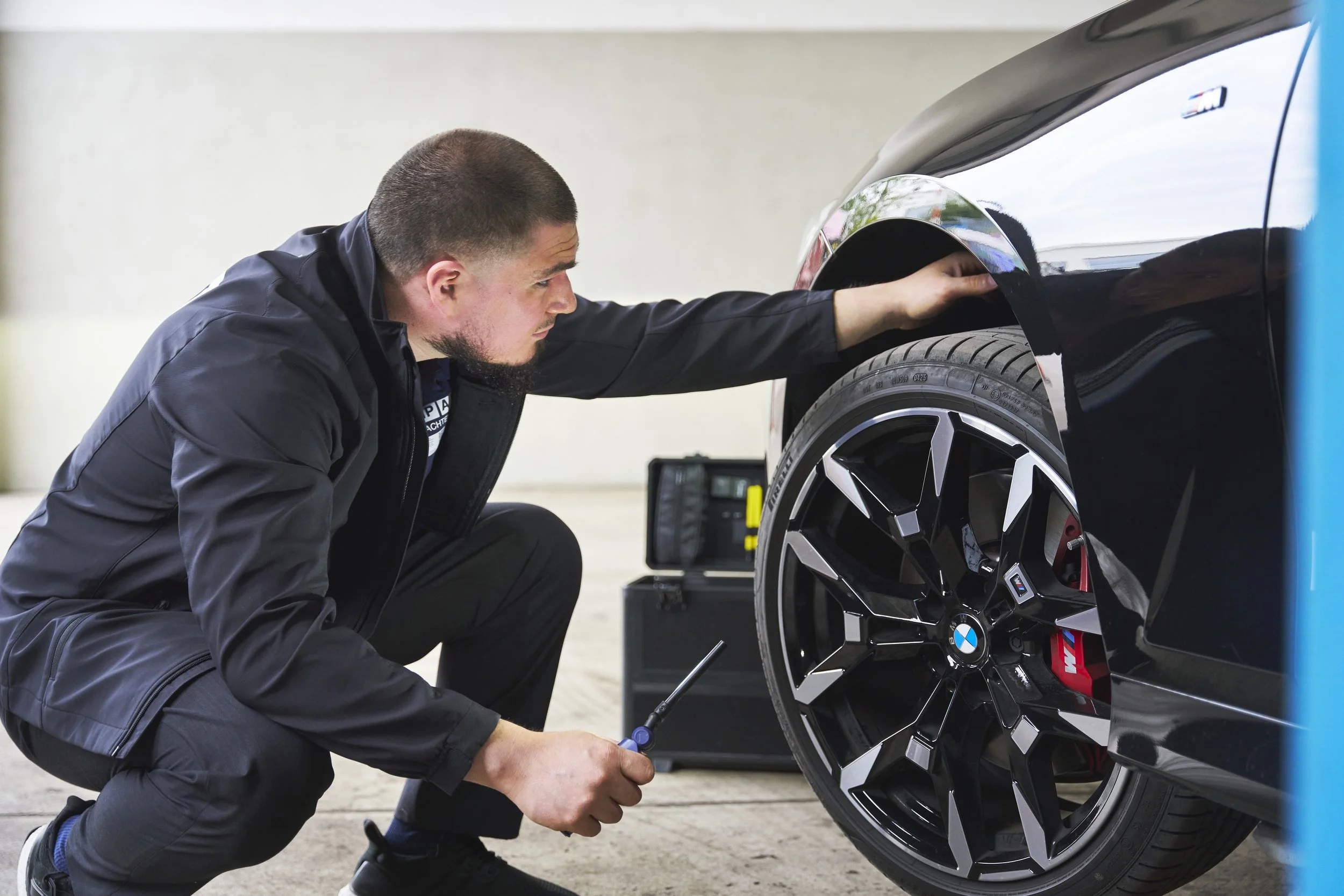Reifen- und Felgenprüfung an einem BMW im Rahmen eines Kfz-Gutachtens
