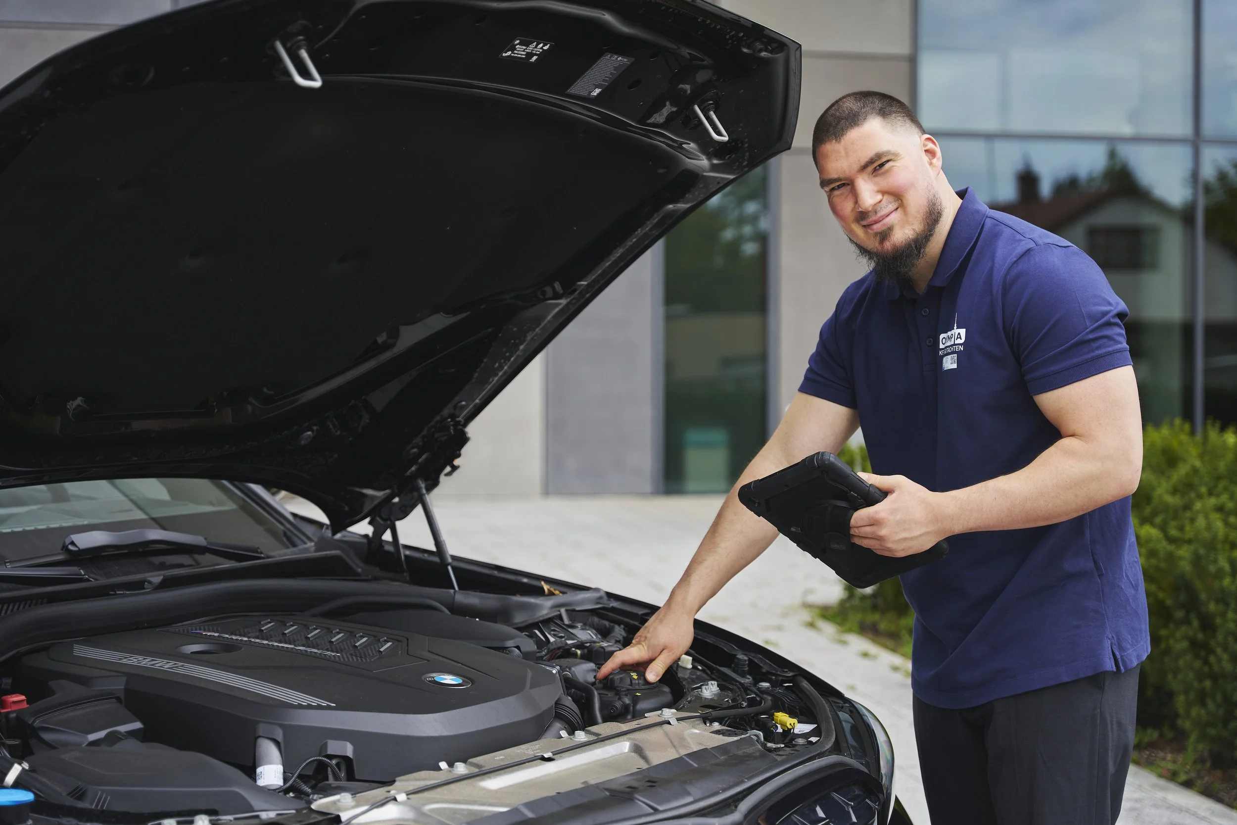 Ali Yetis, Kfz-Gutachter bei Olympia Kfz-Gutachten, führt eine Motordiagnose an einem BMW in München durch
